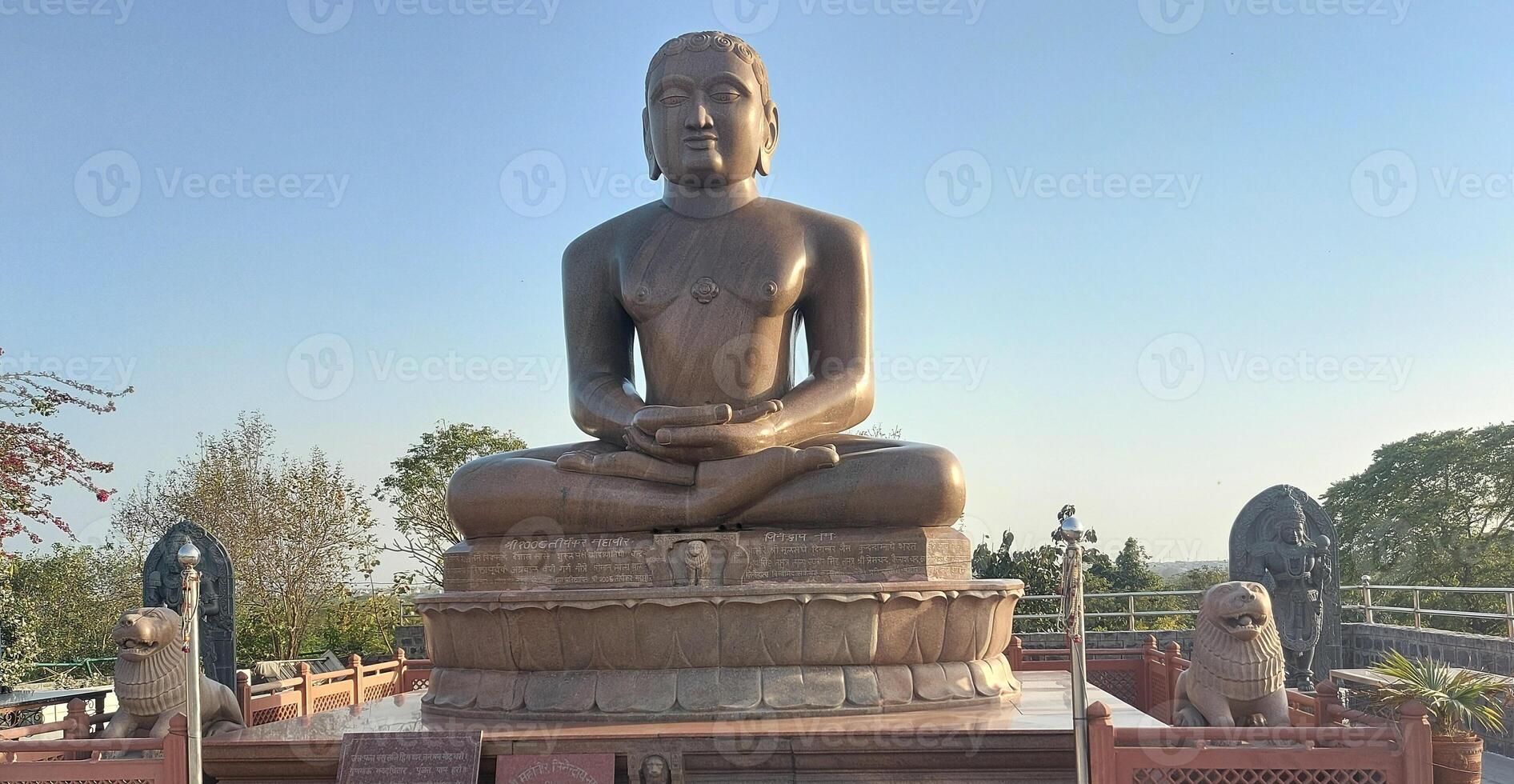 A large statue of buddha sitting on a stone photo