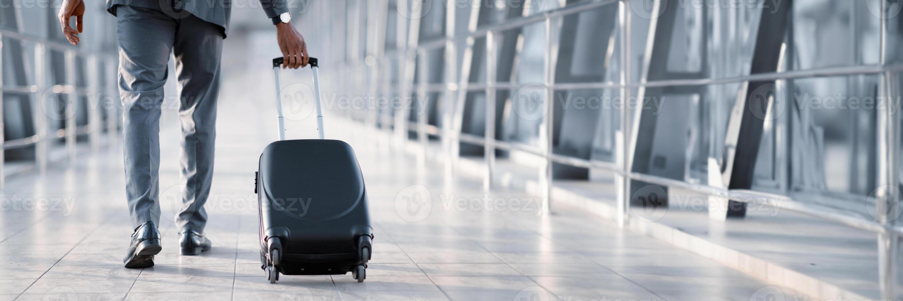 Cropped of African American Businessman At Airport Moving To Terminal Gate For Business Trip, Back View, Panorama With Copy Space photo