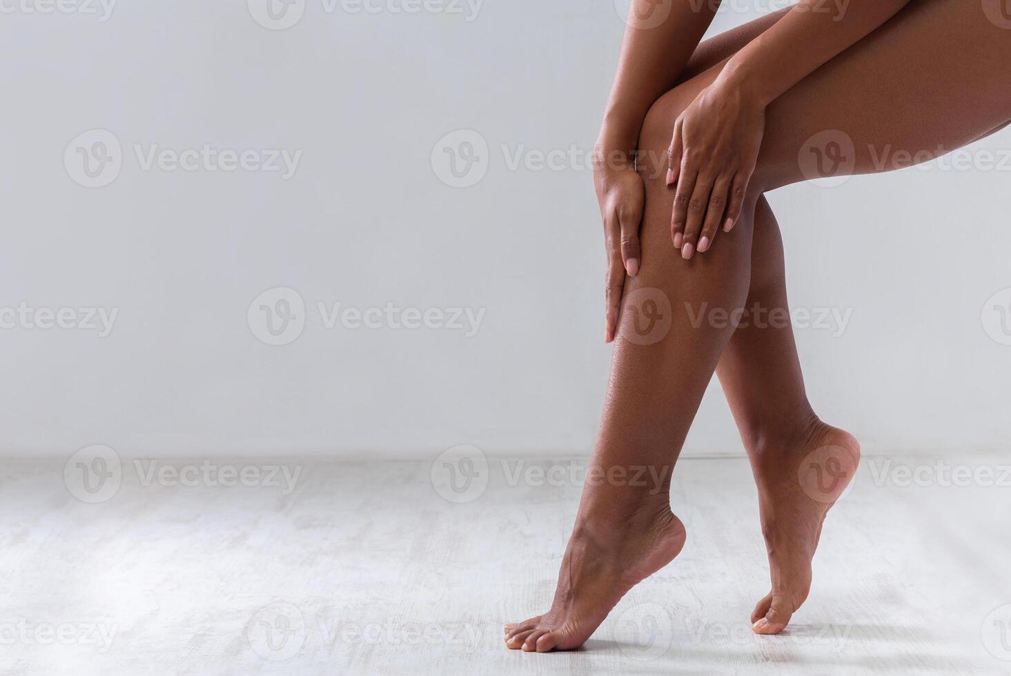 Cropped of female legs, black woman touching her skin after waxing or epilation, copy space photo