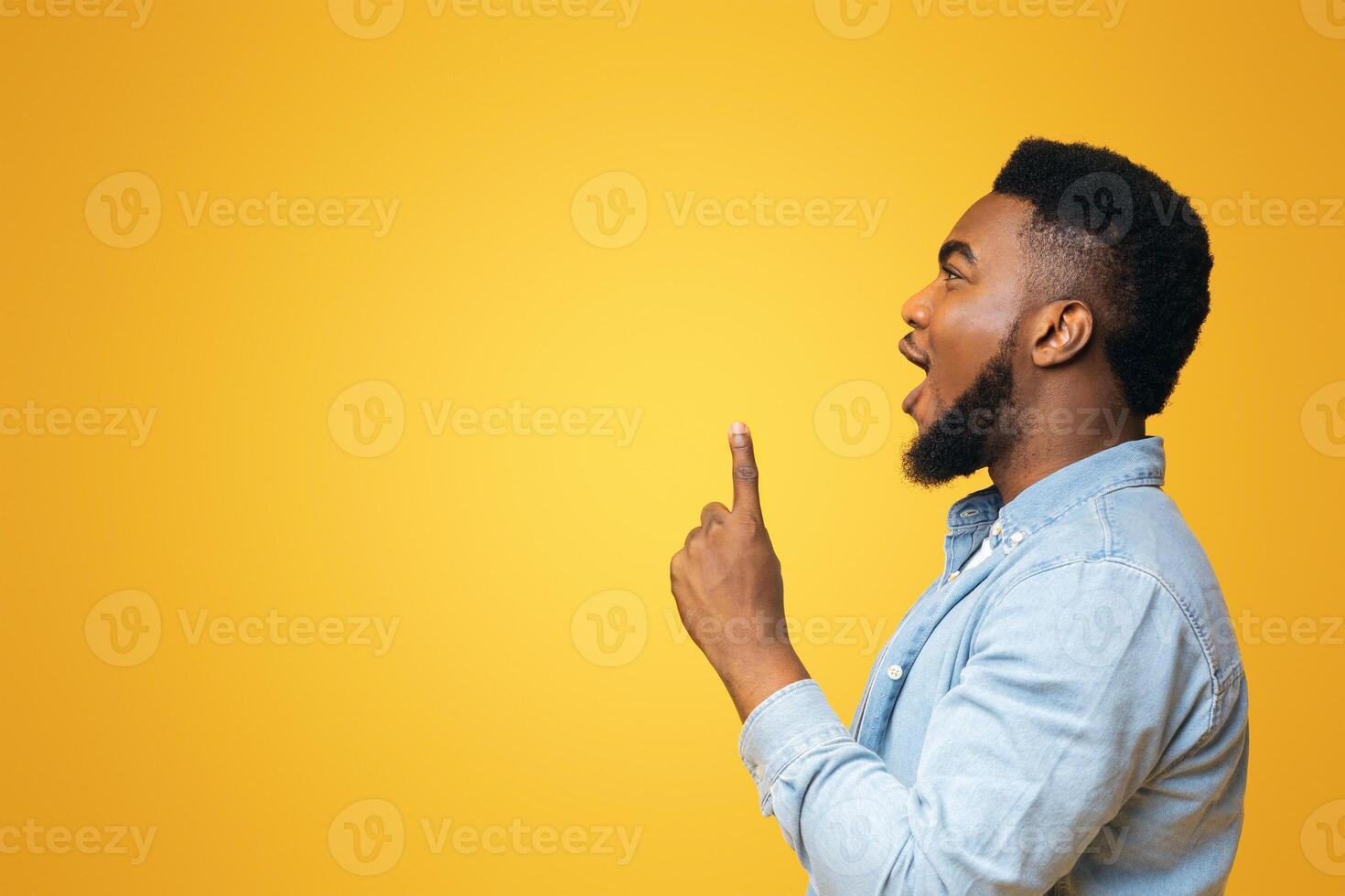 Eureca. Black man having idea, looking and pointing upwards at copy space on yellow background, panorama photo