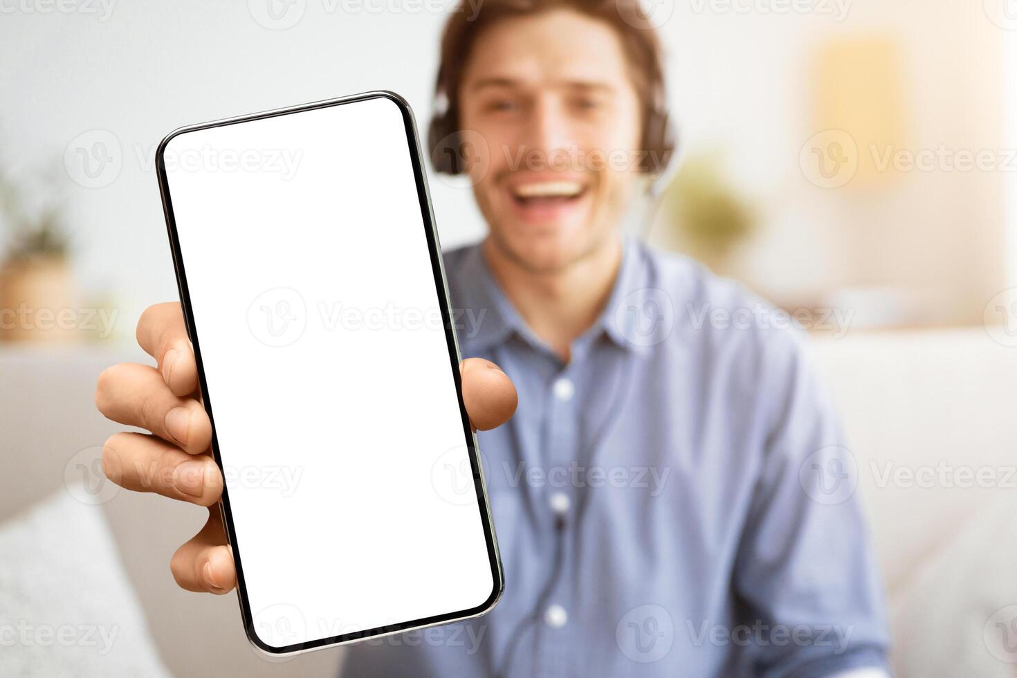 Cool Music App. Man Gesturing Thumbs-Up Listening To Song Or Podcast Via Wireless Headphones At Home. Free Space photo
