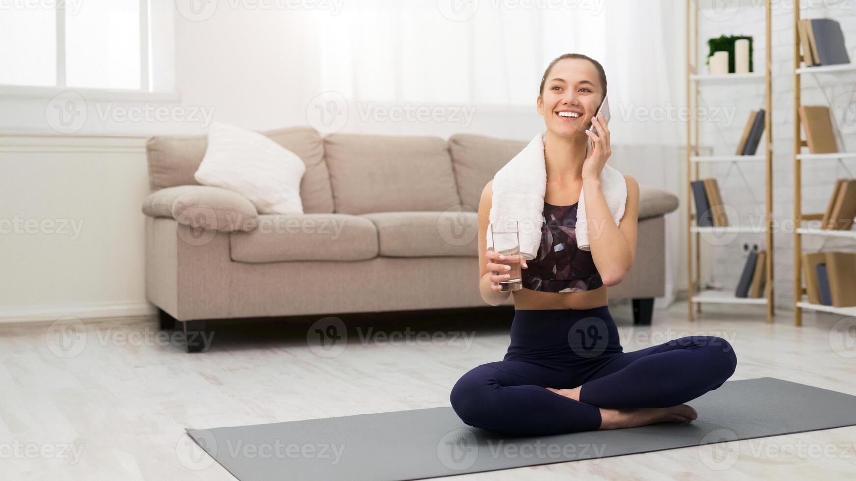 Fit Girl Refreshing With Water And Talking On Phone After Exercising At Home, Free Space photo