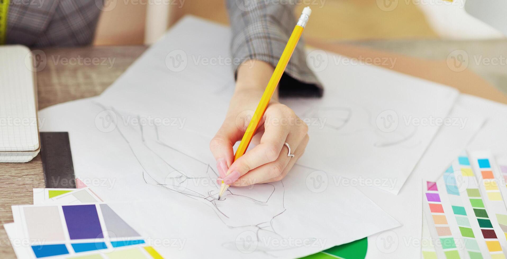 Fashion caree. Designer drawing sketches for clothes with color swatches on table photo
