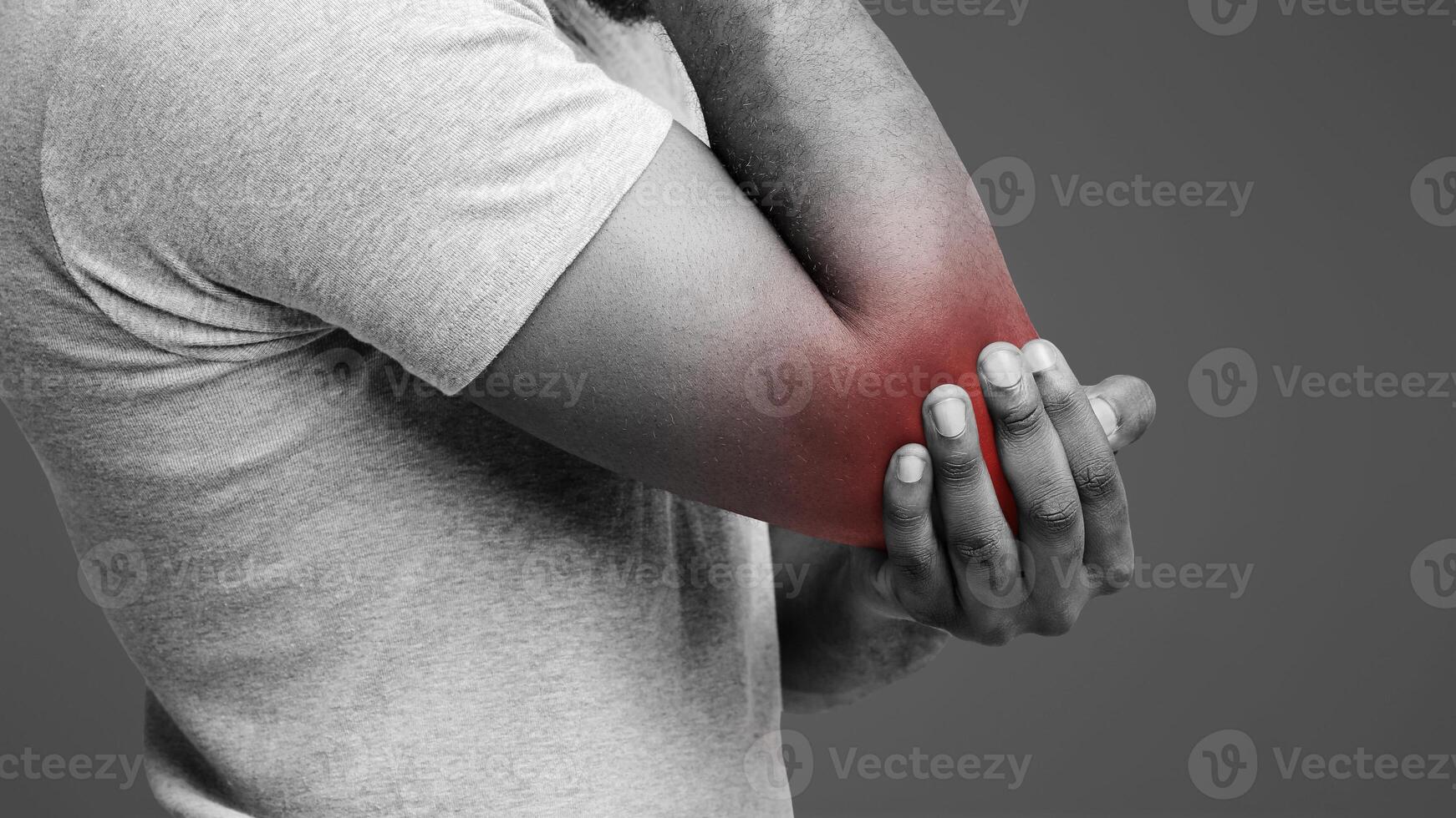 Cropped of black man rubbing his injured highlighted with red elbow, side view, copy space photo