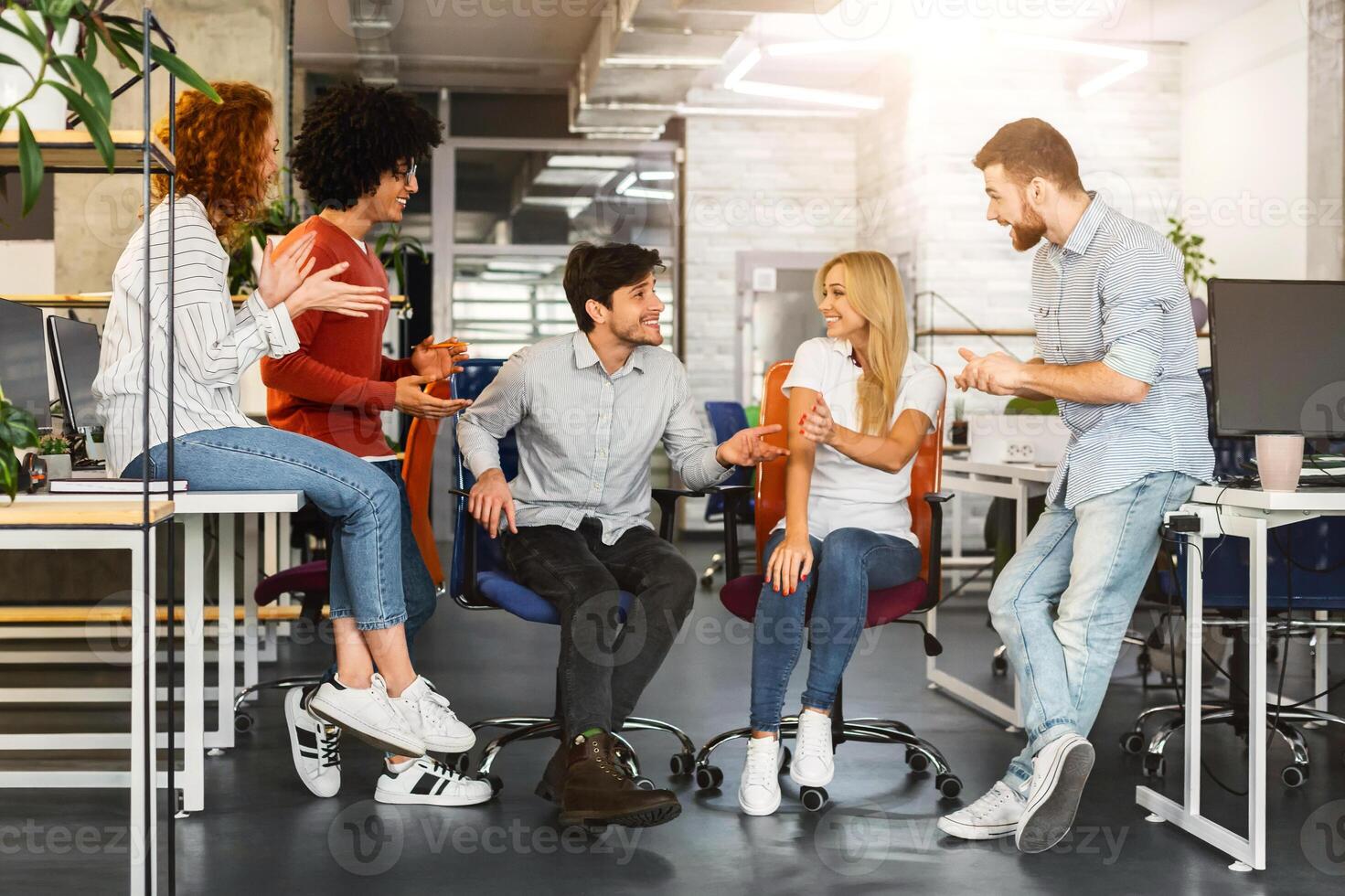 Diverse Professionals Strategizing at Open-Plan Workspace. Diverse group of professionals sharing innovative ideas in an open-plan workspace, fostering an inclusive and energized team dynamic. photo