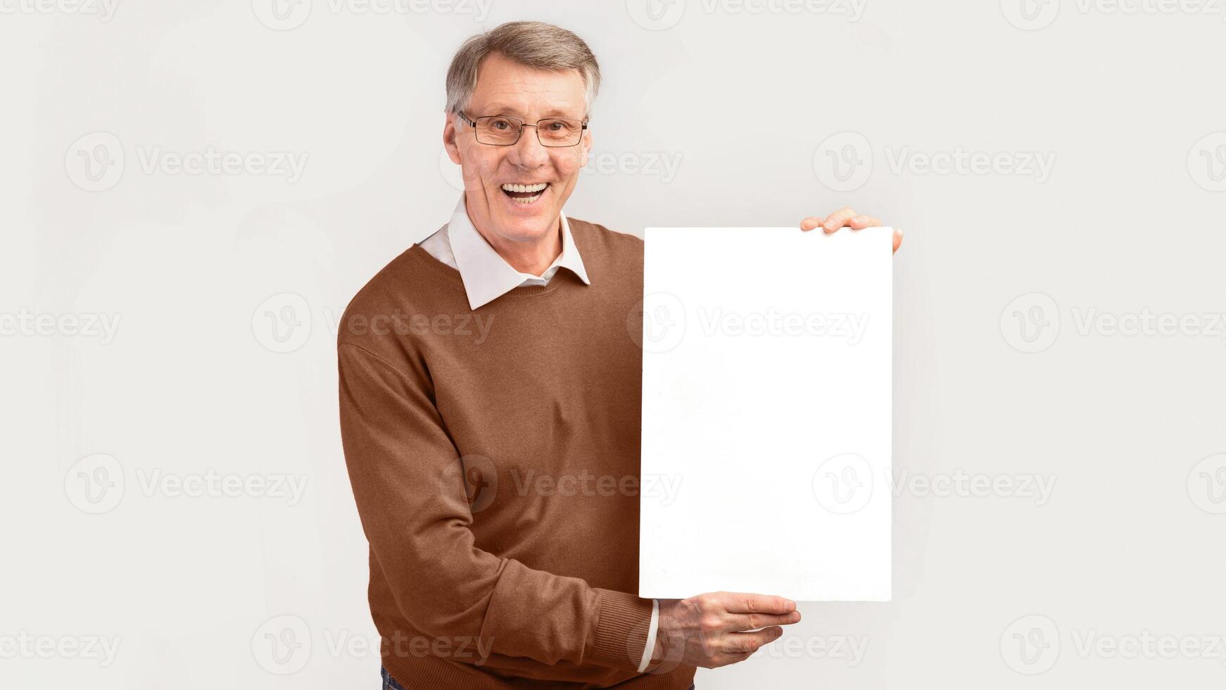 Smiling Senior Man Holding Blank White Poster Standing Over Studio Background. Mockup, Panorama photo