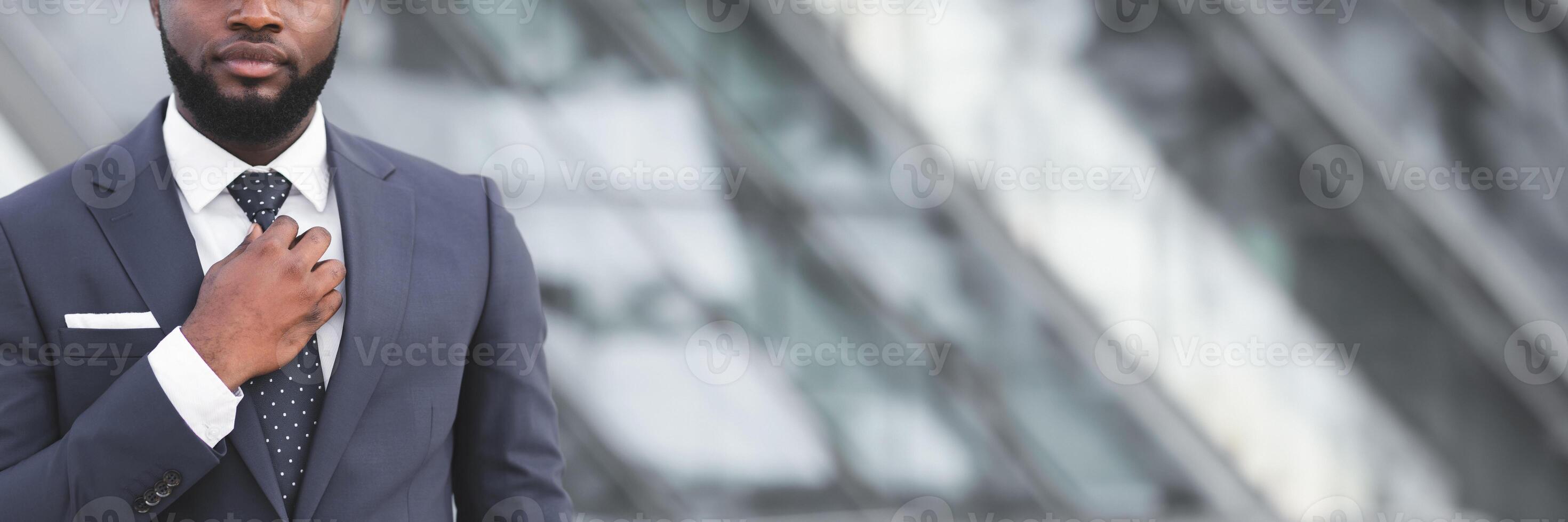 Business Life. Unrecognizable Black Businessman Adjusting Necktie Walking In City Center, Cropped, Empty Space photo