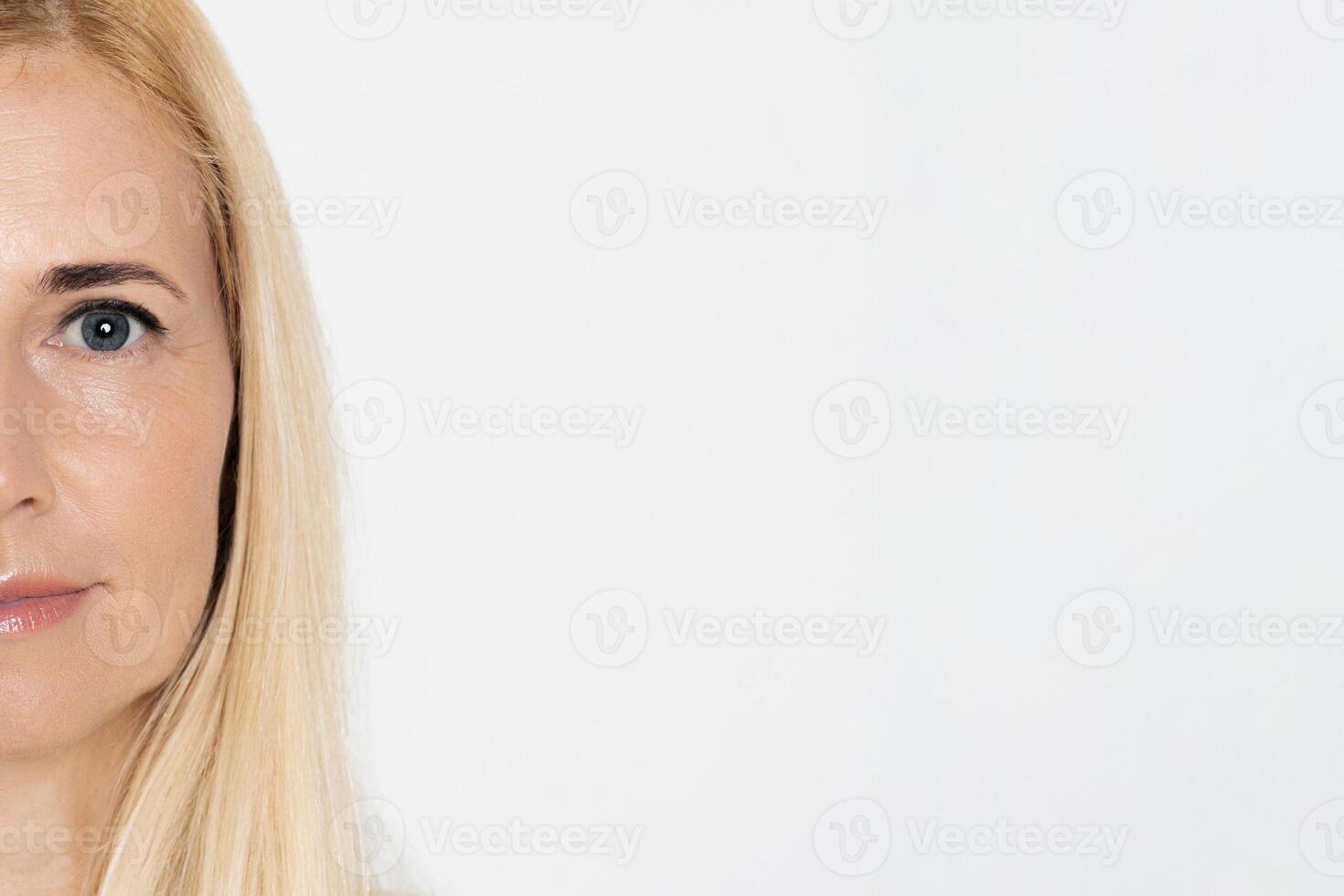 The image features a close-up portrait of a woman with long, straight blonde hair. The focus of the image is her face, specifically her blue eyes, copy space photo