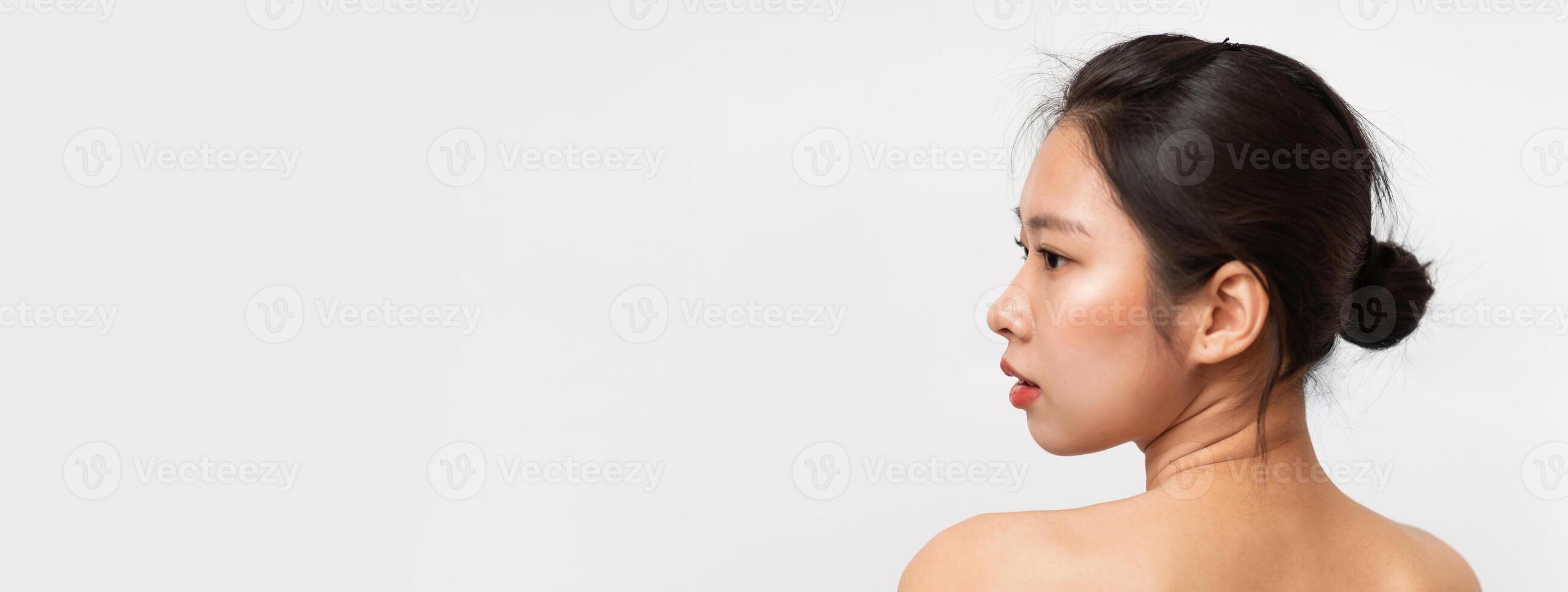 Naked korean lady posing on white studio background, back view of topless asian woman looking at copy space, panorama. Woman sensuality concept photo