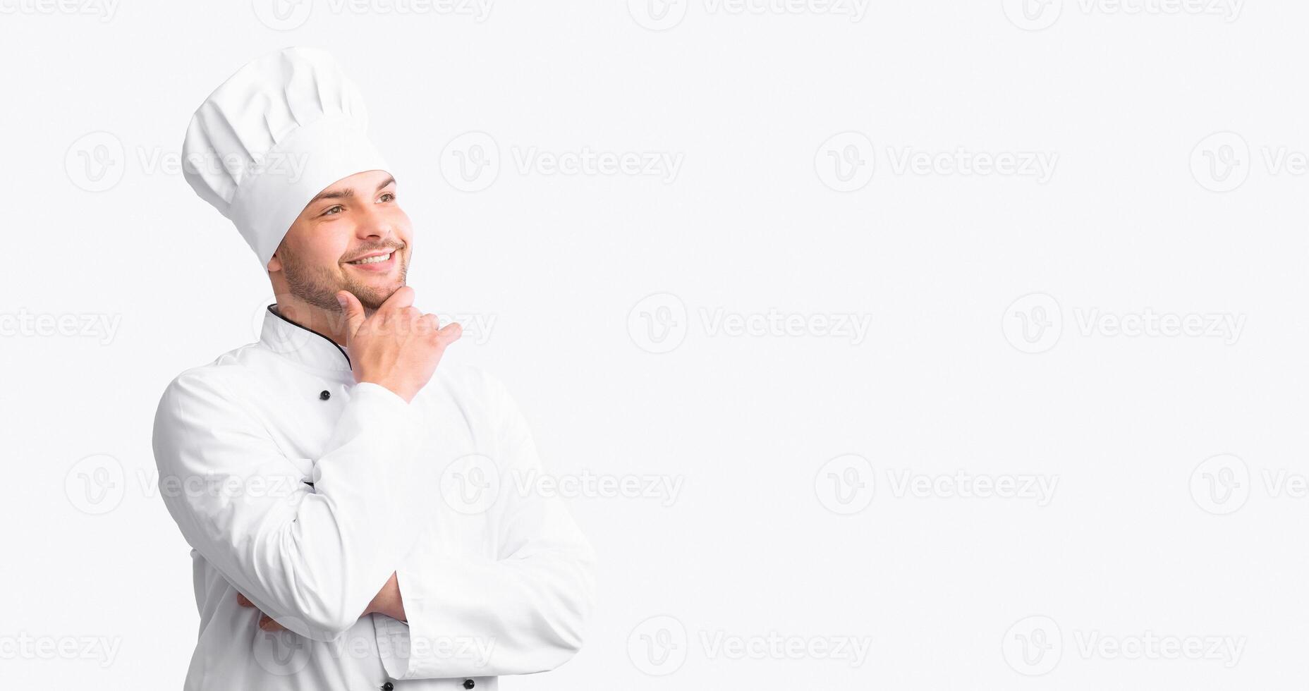 Happy Chef Man Thinking And Dreaming About Own Restaurant Posing Touching Chin Over White Background. Studio Shot, Empty Space photo