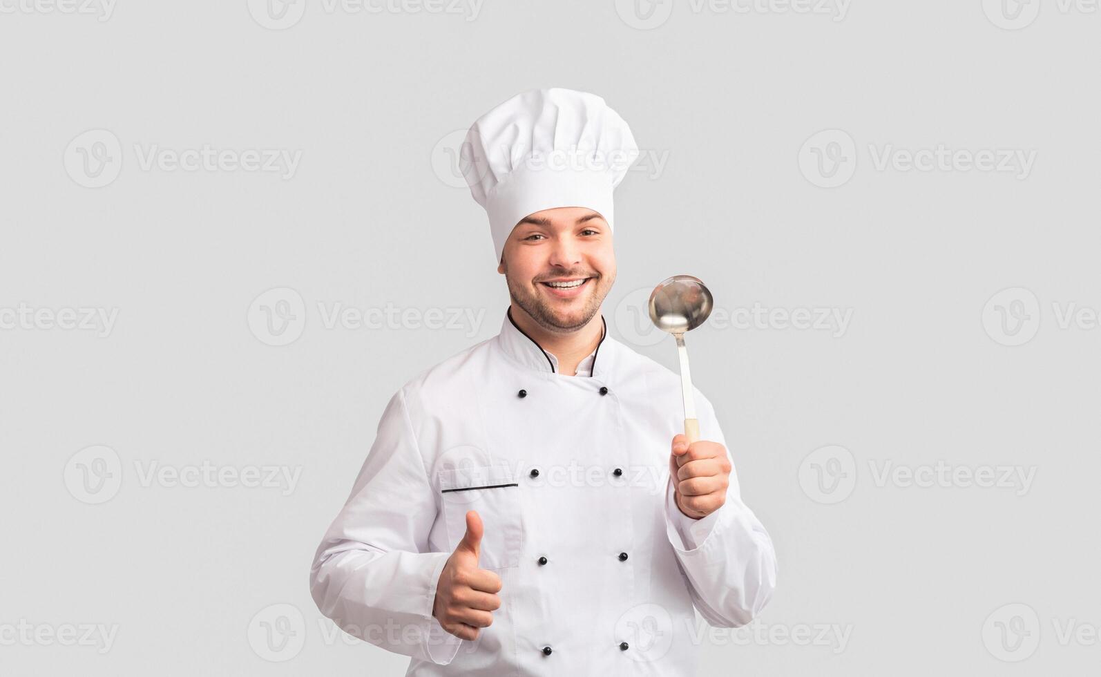 I Like Cooking. Smiling Chef Man Holding Ladle Spoon Gesturing Thumbs Up Standing Over White Studio Background. Panorama photo