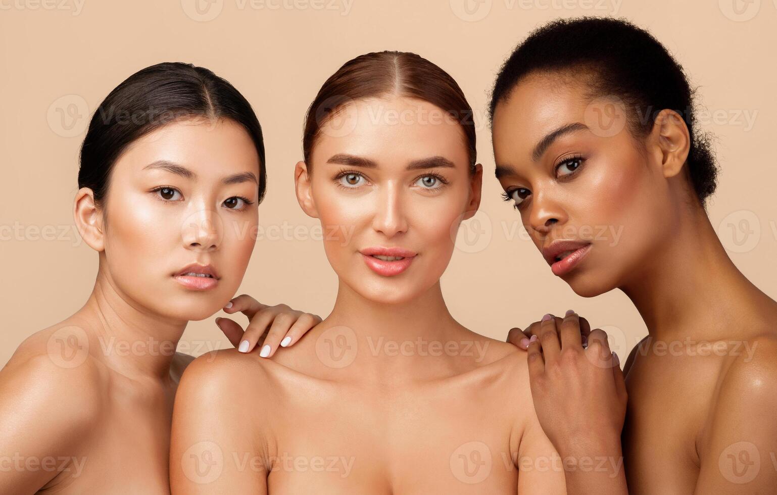 Multiethnic Beauty Concept. Three Young Women Posing Together Shirtless, Looking At Camera Over Gray Background. Studio Shot photo