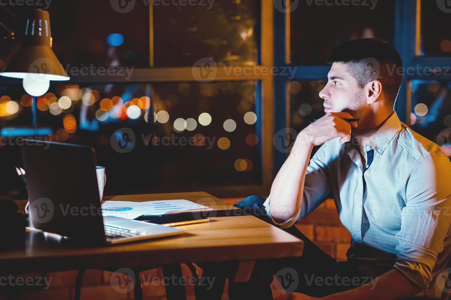 Business Career Concept. Thoughtful Guy Sitting At Work At Night Thinking On Business Project In Modern Office. Copy Space photo
