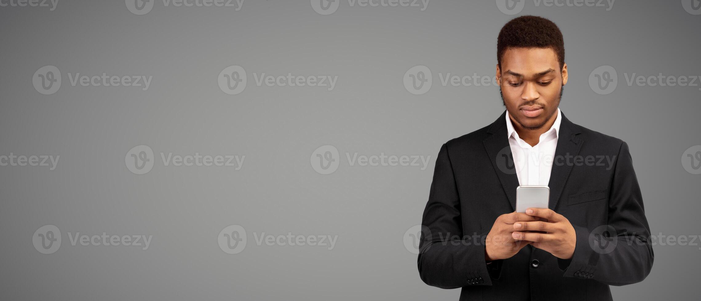 Busy Businessman. Serious afro man using phone thinking about question, white background, panorama, copyspace photo