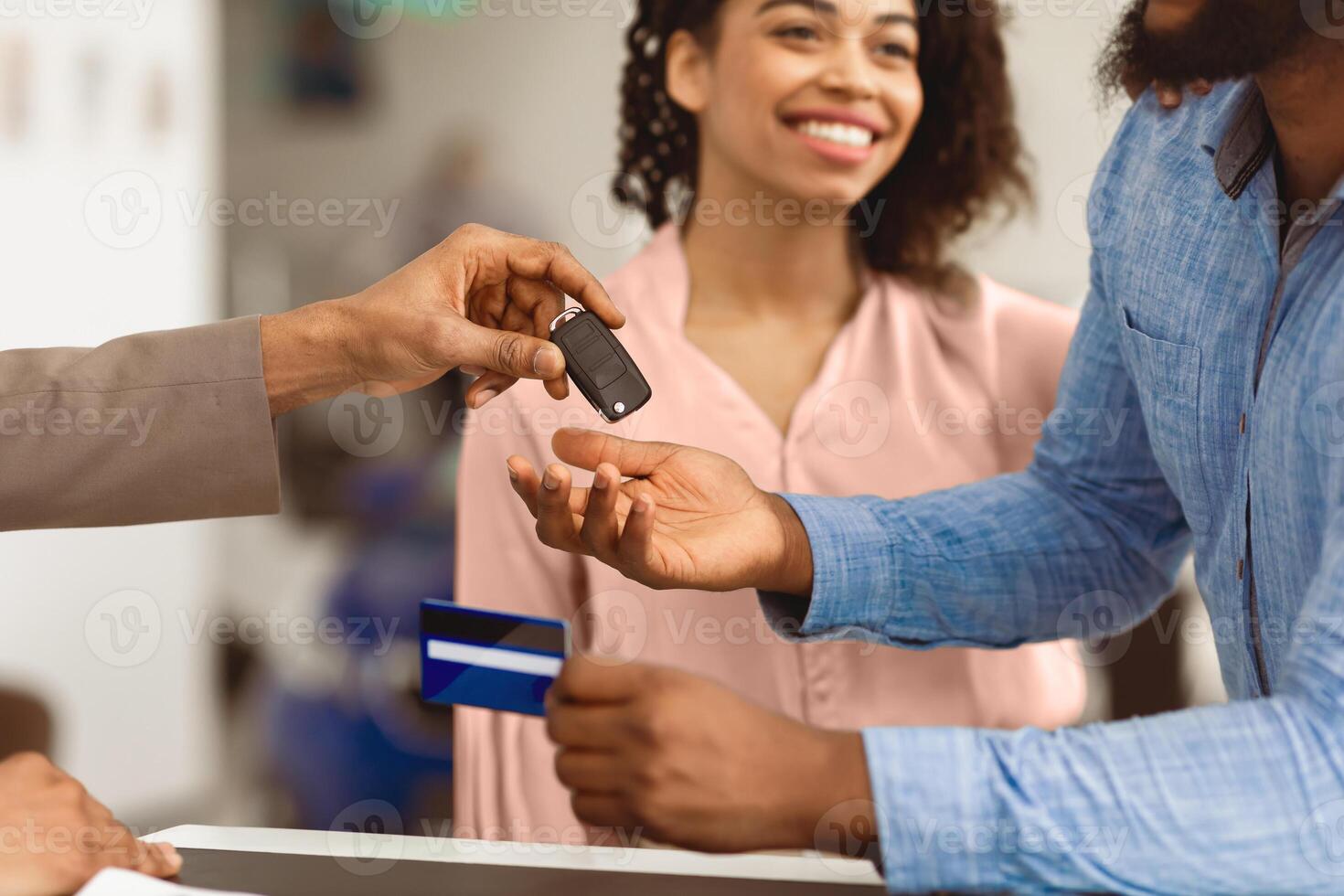 African American Couple Buying New Car Paying With Credit Card And Taking Key In Auto Dealership Office. Closeup, Selective Focus photo