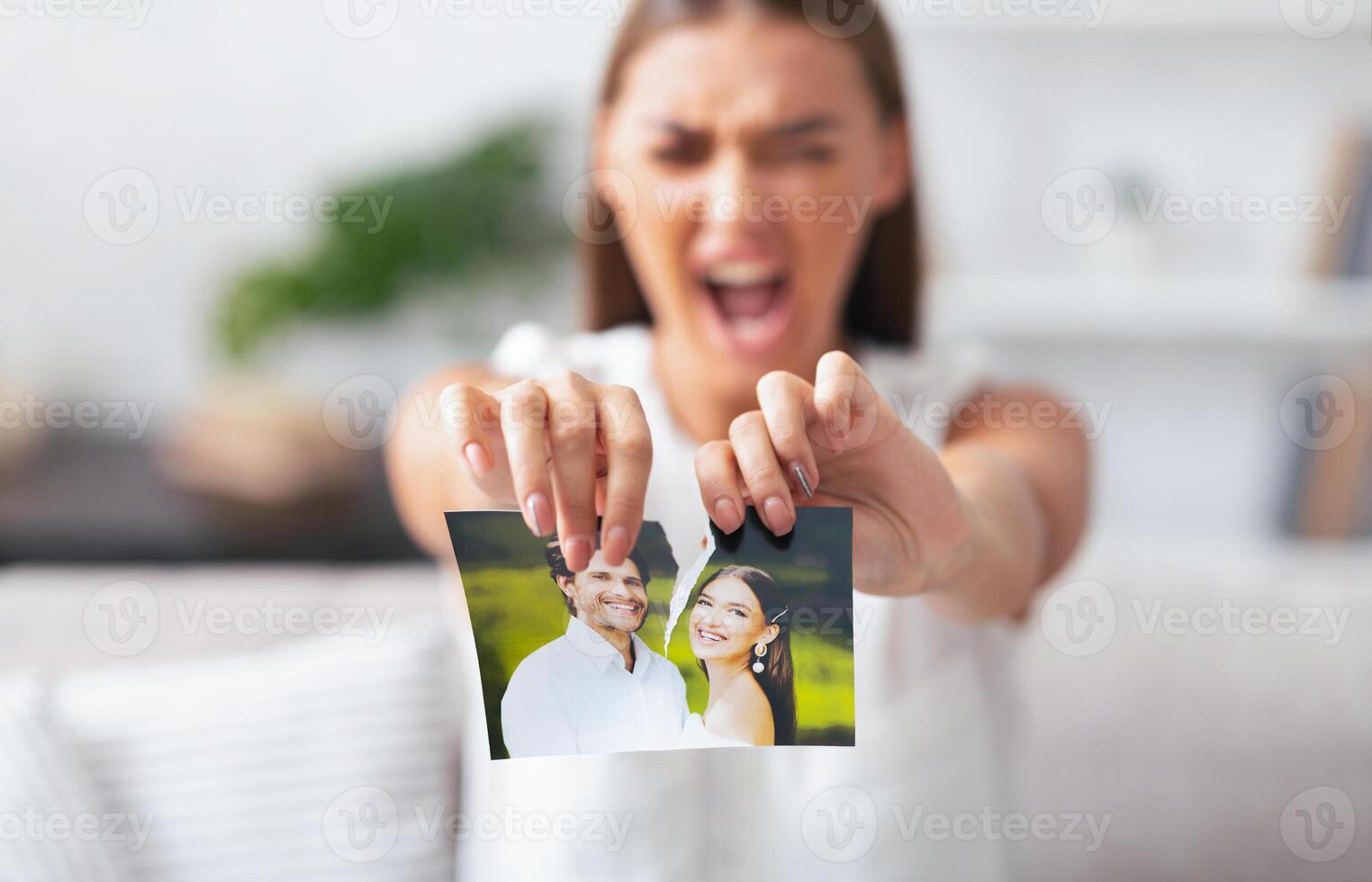 Divorce. Angry Woman Ripping Wedding Photo With Ex-Husband After Breakup Indoor. Selective Focus