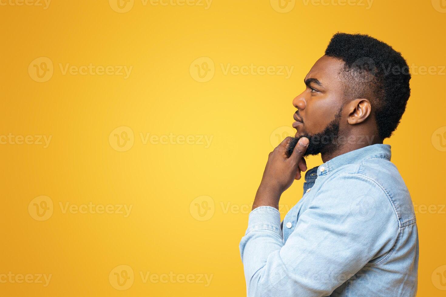 Searching for solution. Thoughtful black man profile portrait on yellow studio background, copy space photo