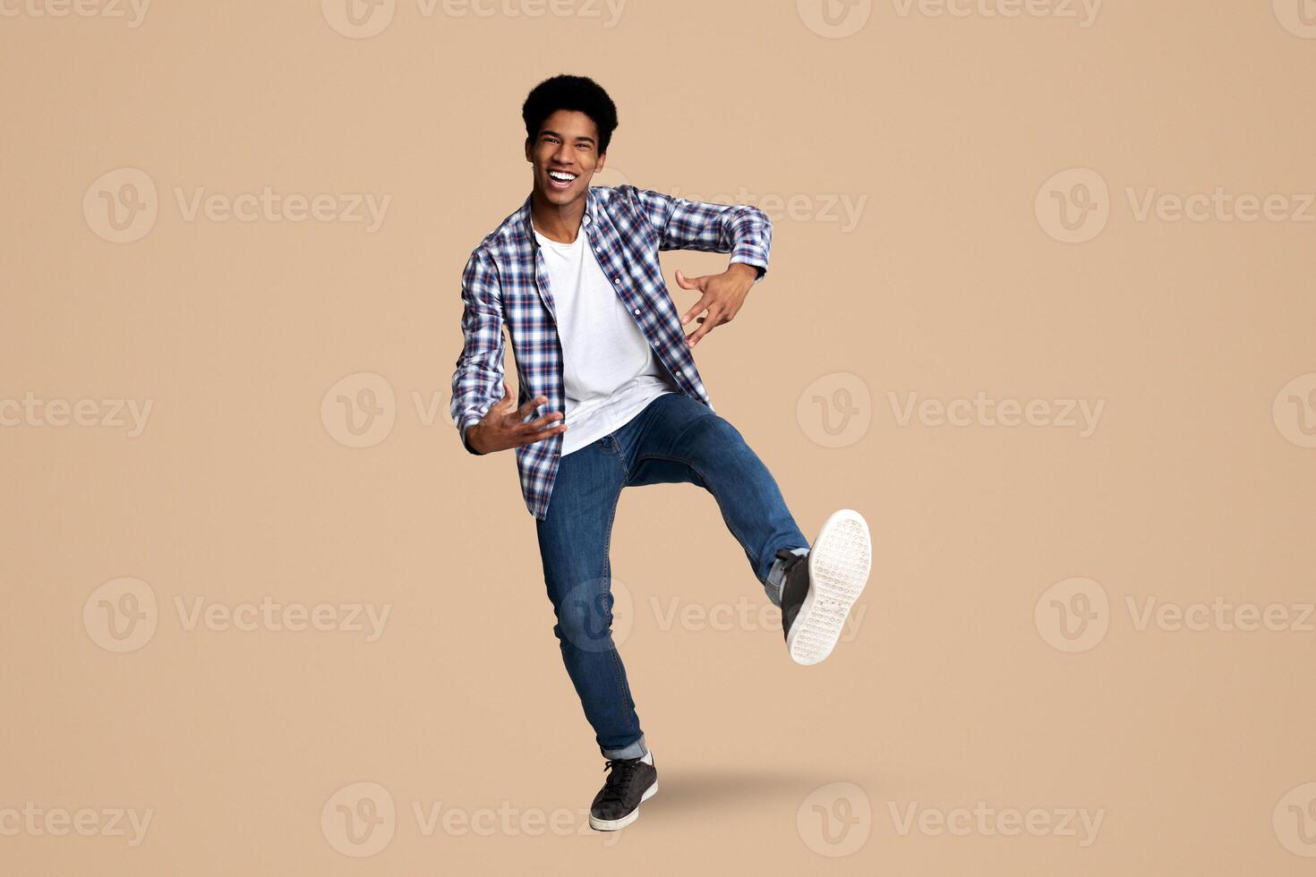 Happy african-american guy having fun, full length, white studio background photo