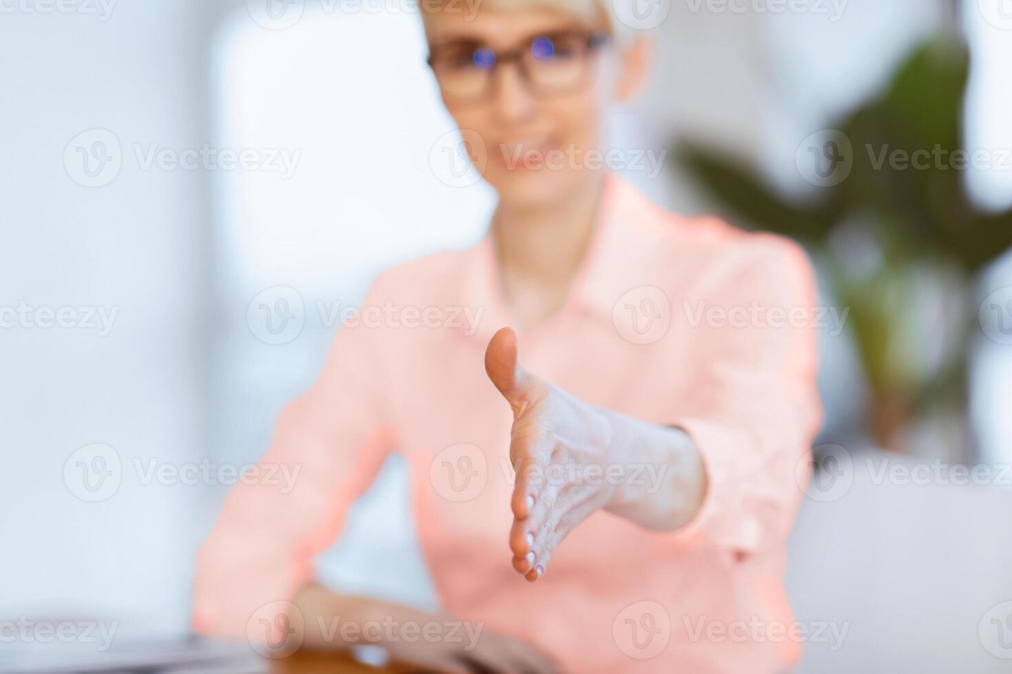 Businesswoman Stretching Hand For Handshake Greeting Sitting In Modern Office. Nice To Meet You. Shallow Depth, Selective Focus photo