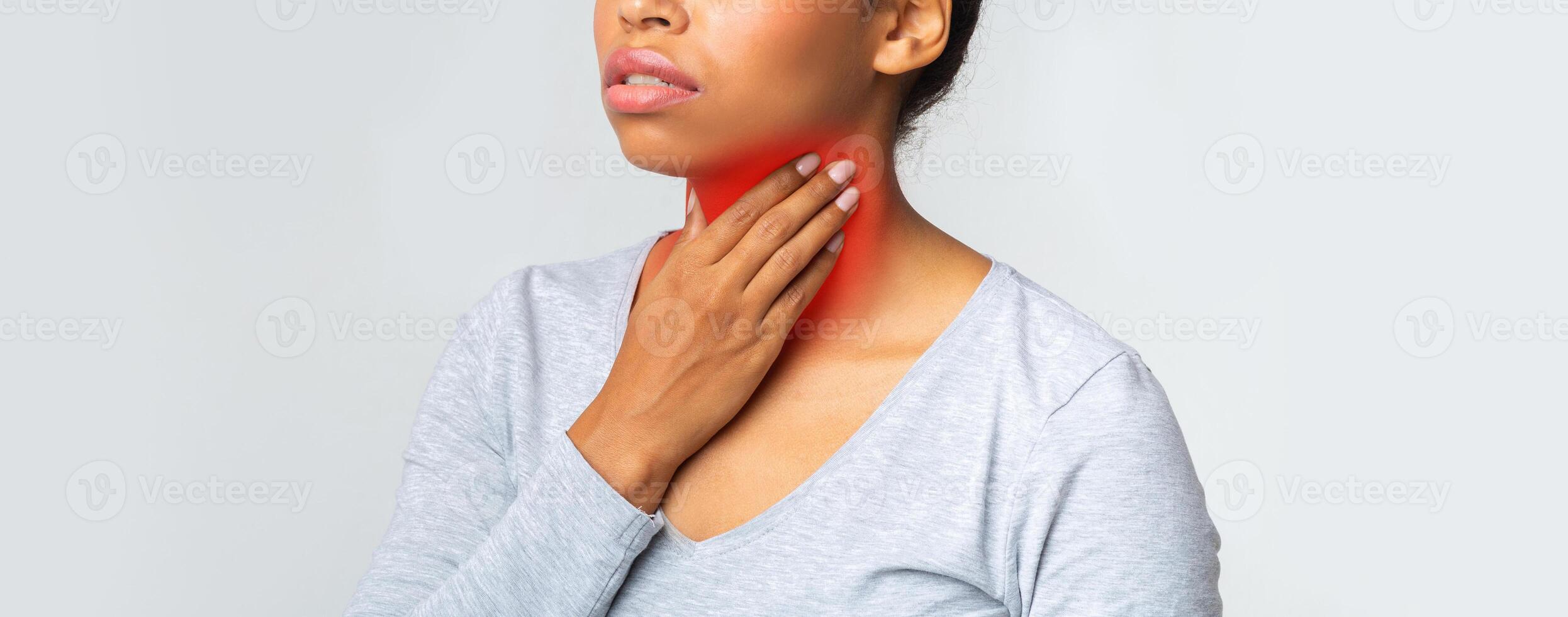 Young black girl suffering from pain in throat, touching inflamed red zone on her neck, panorama with empty space photo