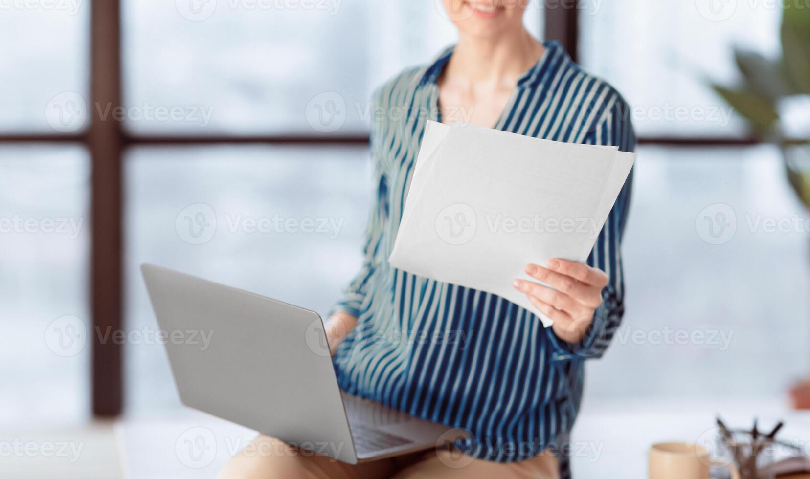 Business Accounting. Unrecognizable Lady Holding Laptop And Documents Sitting In Modern Office. Cropped, Shallow Depth, Selective Focus photo