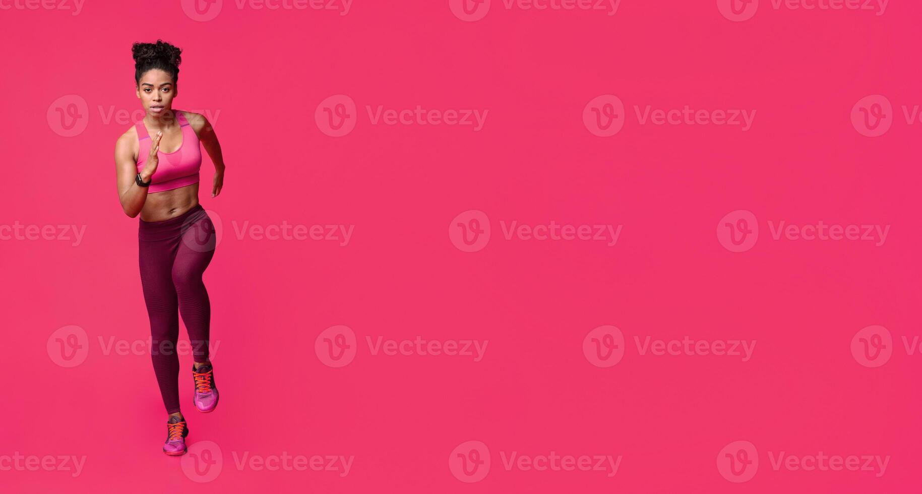 Running black fitness girl over red studio background photo