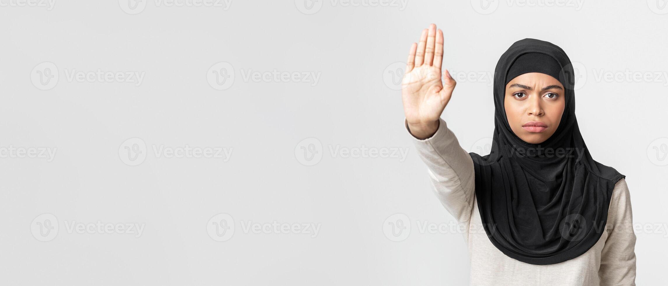 Stop Violence Concept. Serious Black Muslim Woman In Hijab Showing No With Her Hand, Tired Of Discrimination, Light Studio Background, Free Space photo