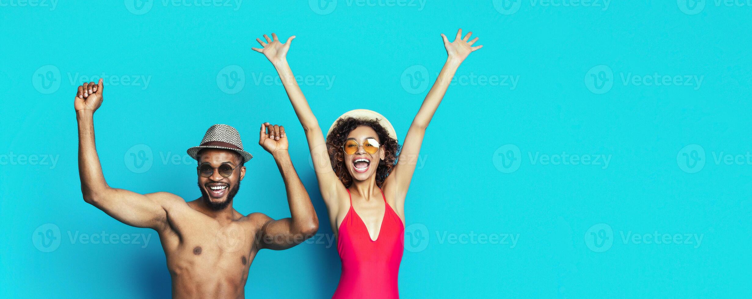 African American man and woman stand in front of a blue background