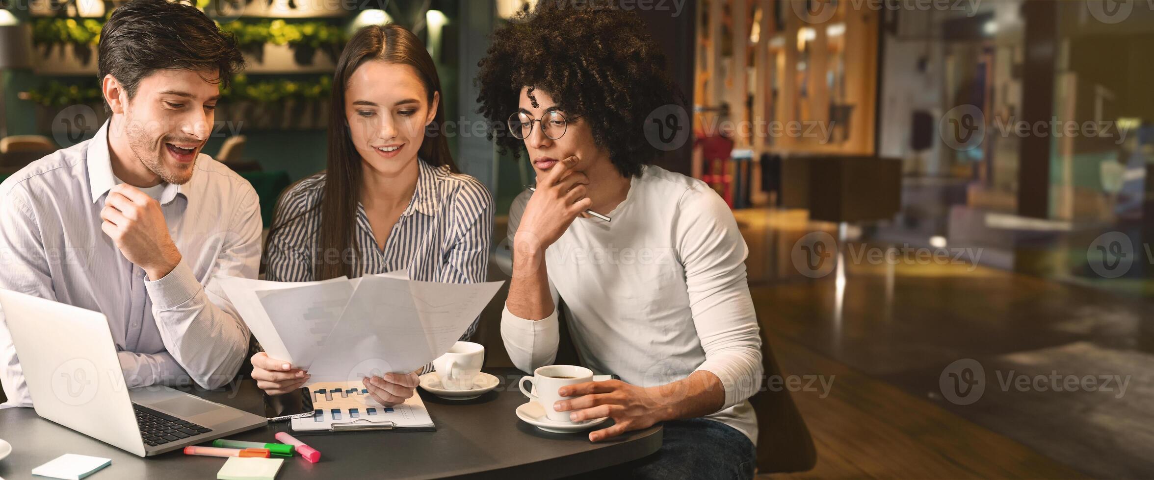 Millennial business team discussing project in cafe, reading contract terms and conditions during business lunch, free space photo