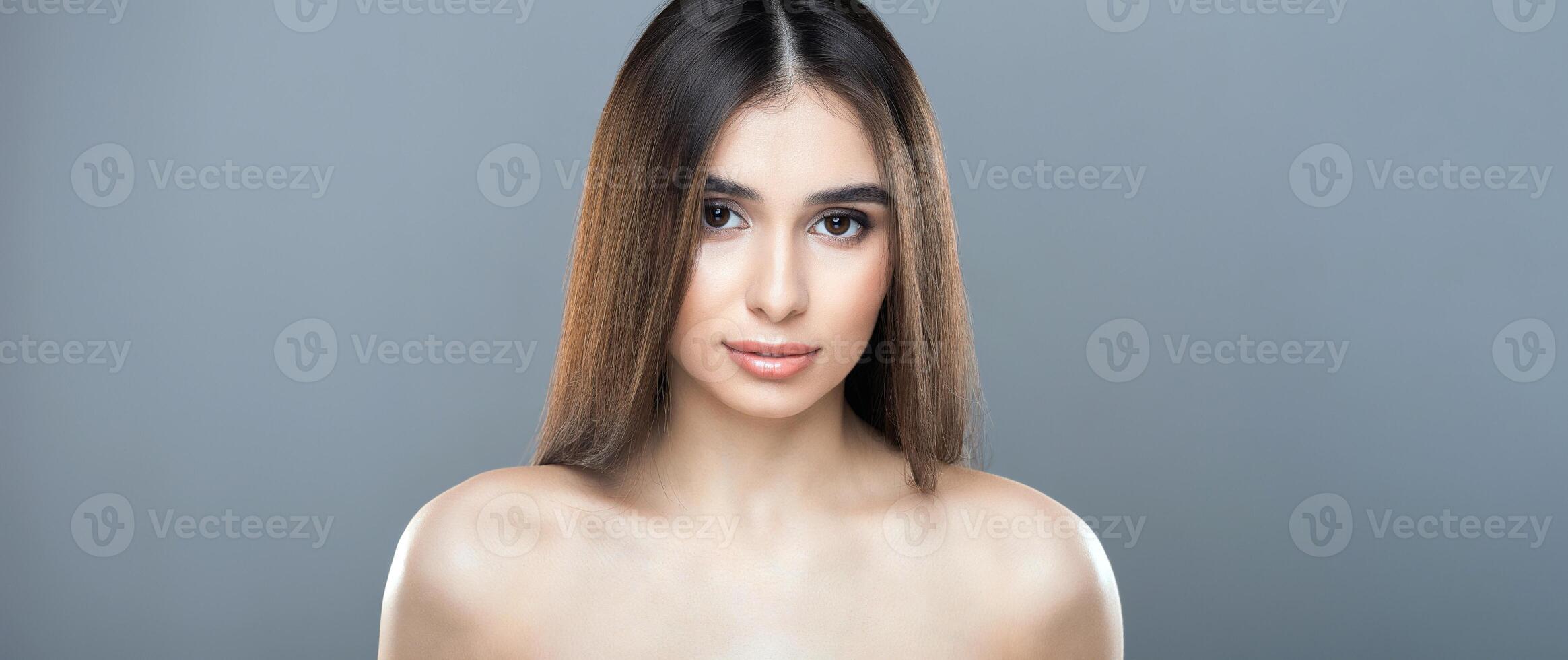 A woman with long hair is standing confidently and posing for a photograph. Her elegant posture and flowing hair create a striking visual. photo
