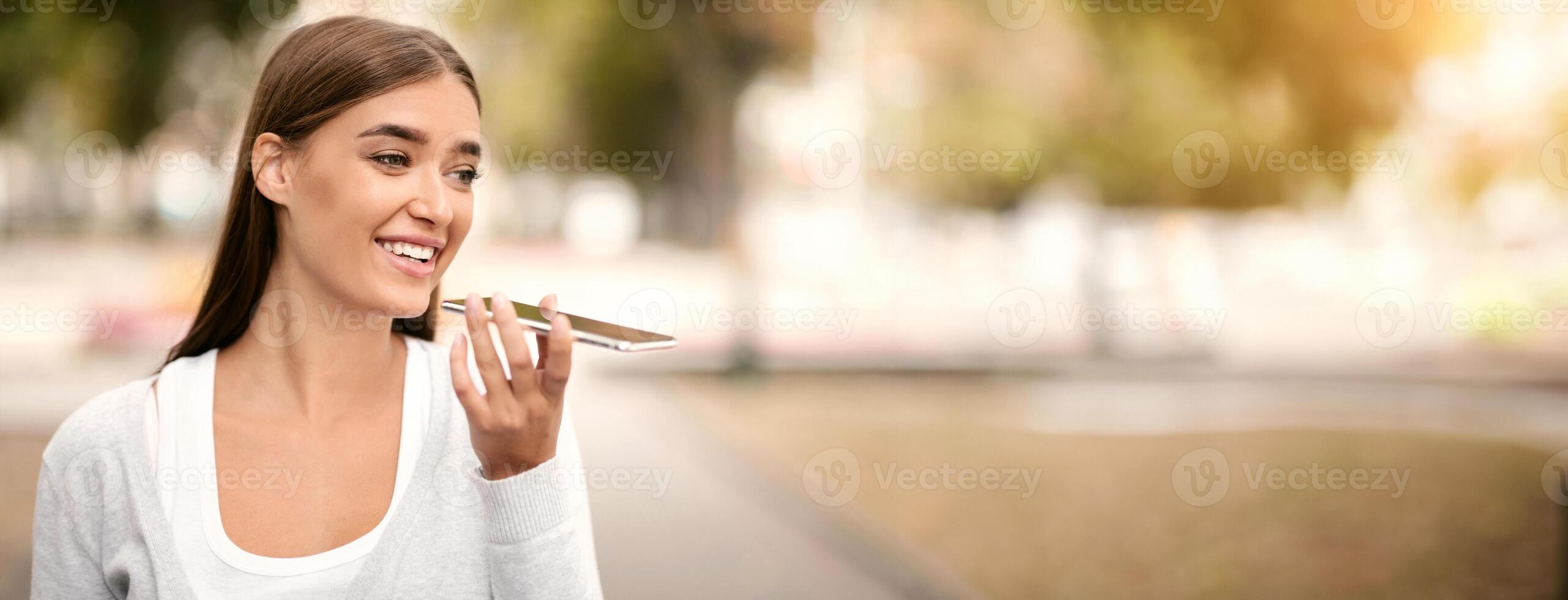 Modern technologies. Woman using digital voice assistant on cellphone outdoor, empty space photo