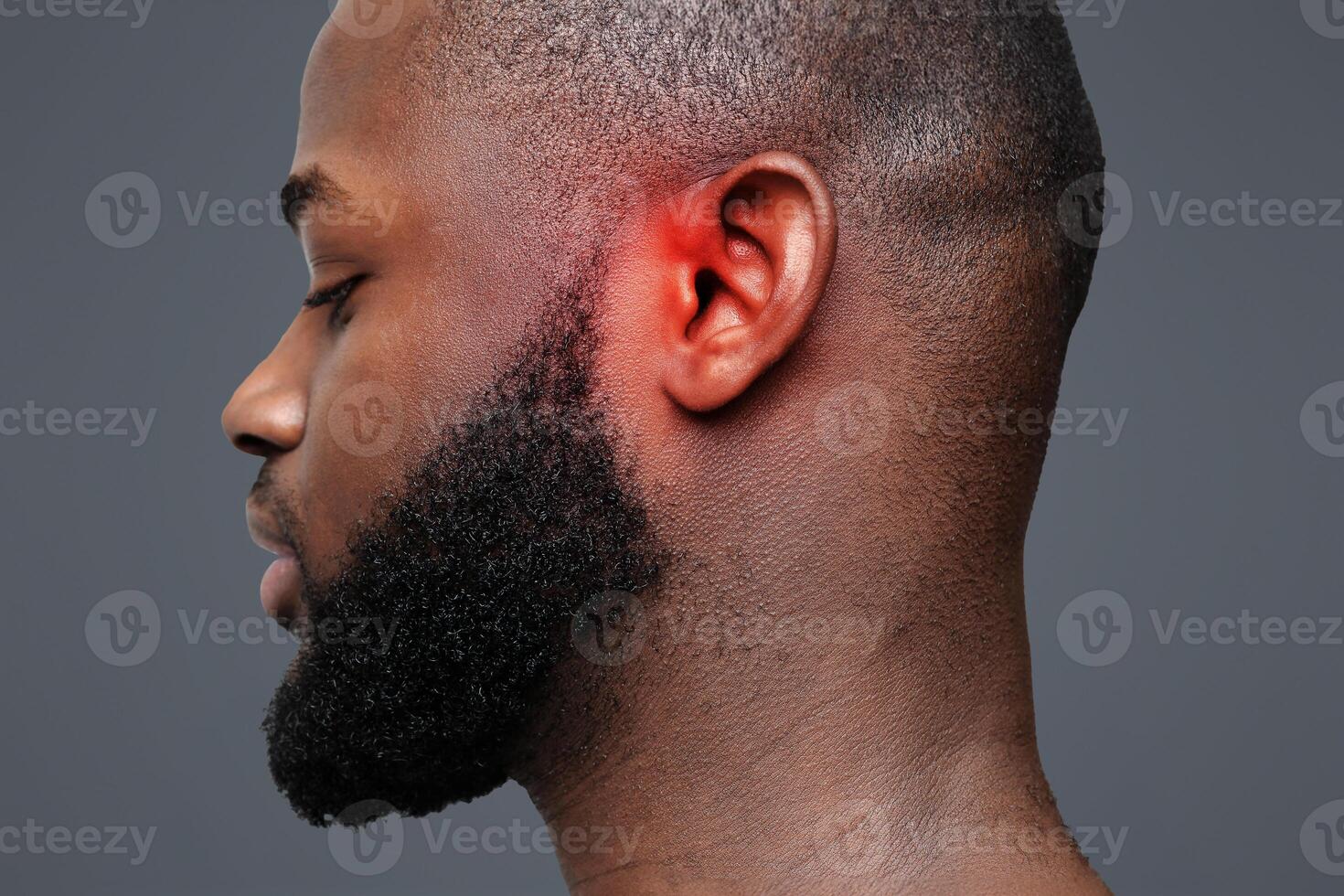 Side view of afro man with inflamed ear, close up photo