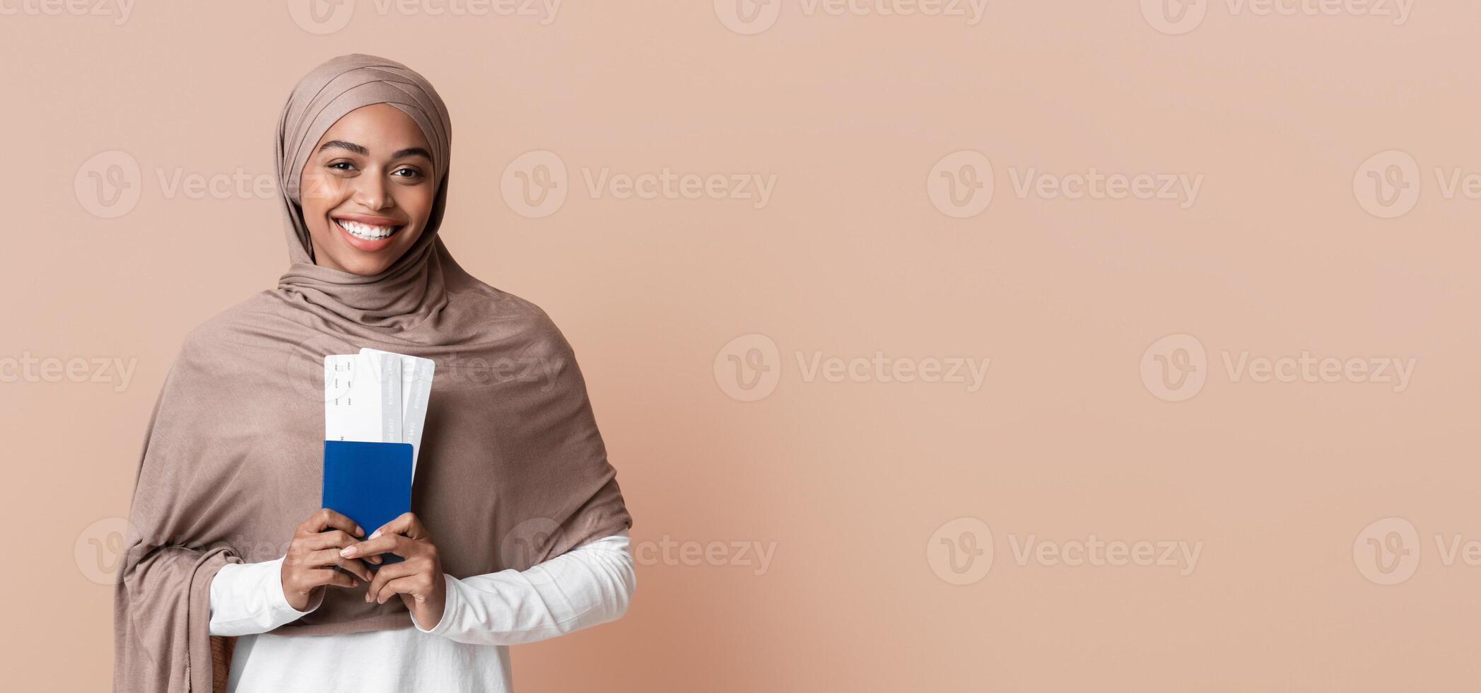Ready for travel. Happy afro muslim woman in hijab holding passport and tickets, going to vacation, yellow background with empty space photo