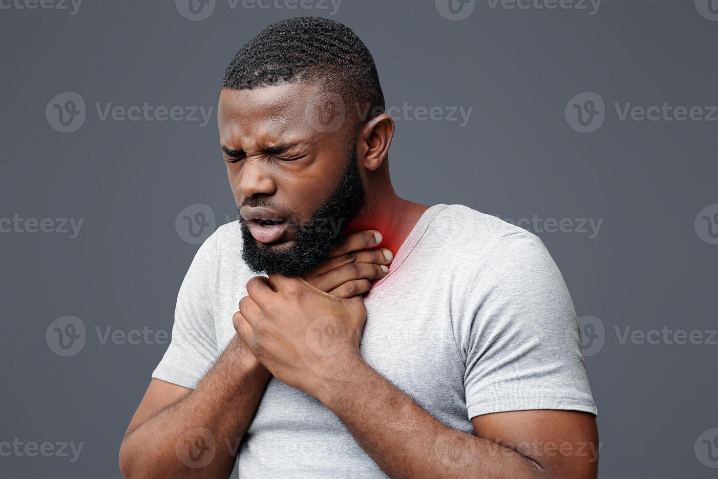 Unhealthy african man touching neck and coughing with closed eyes over white background, copy space photo