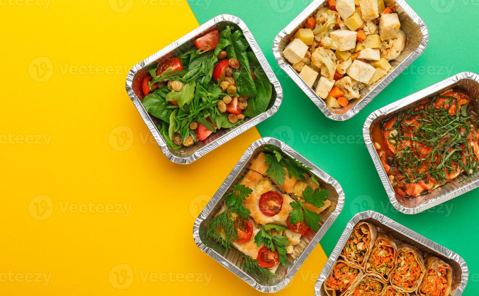 Healthy meals delivery. Casserole, vegetarian rolls, fresh and baked vegetables salads in foil take away boxes on abstract bright background. Eating right concept, copy space, top view. photo