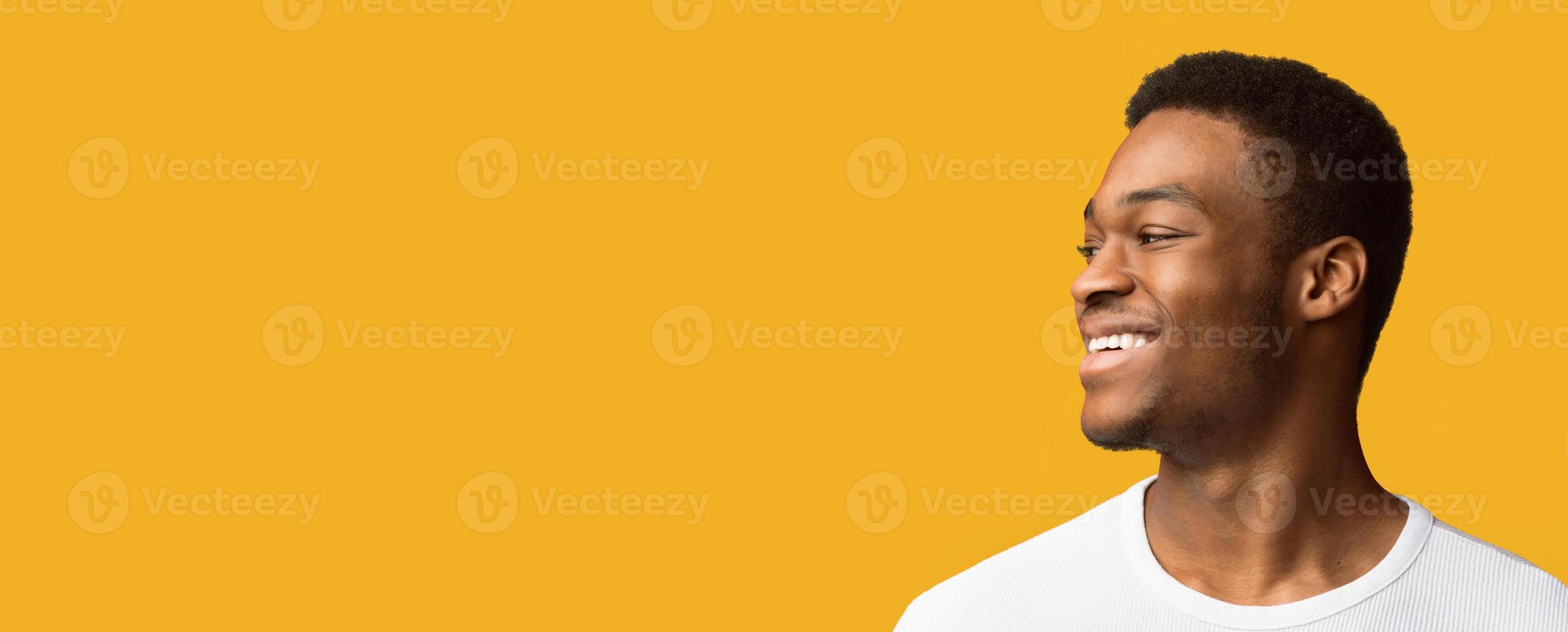 Half-Turned Smiling African American Man Looking At Copy Space Isolated Over Orange Studio Background, Panorama photo