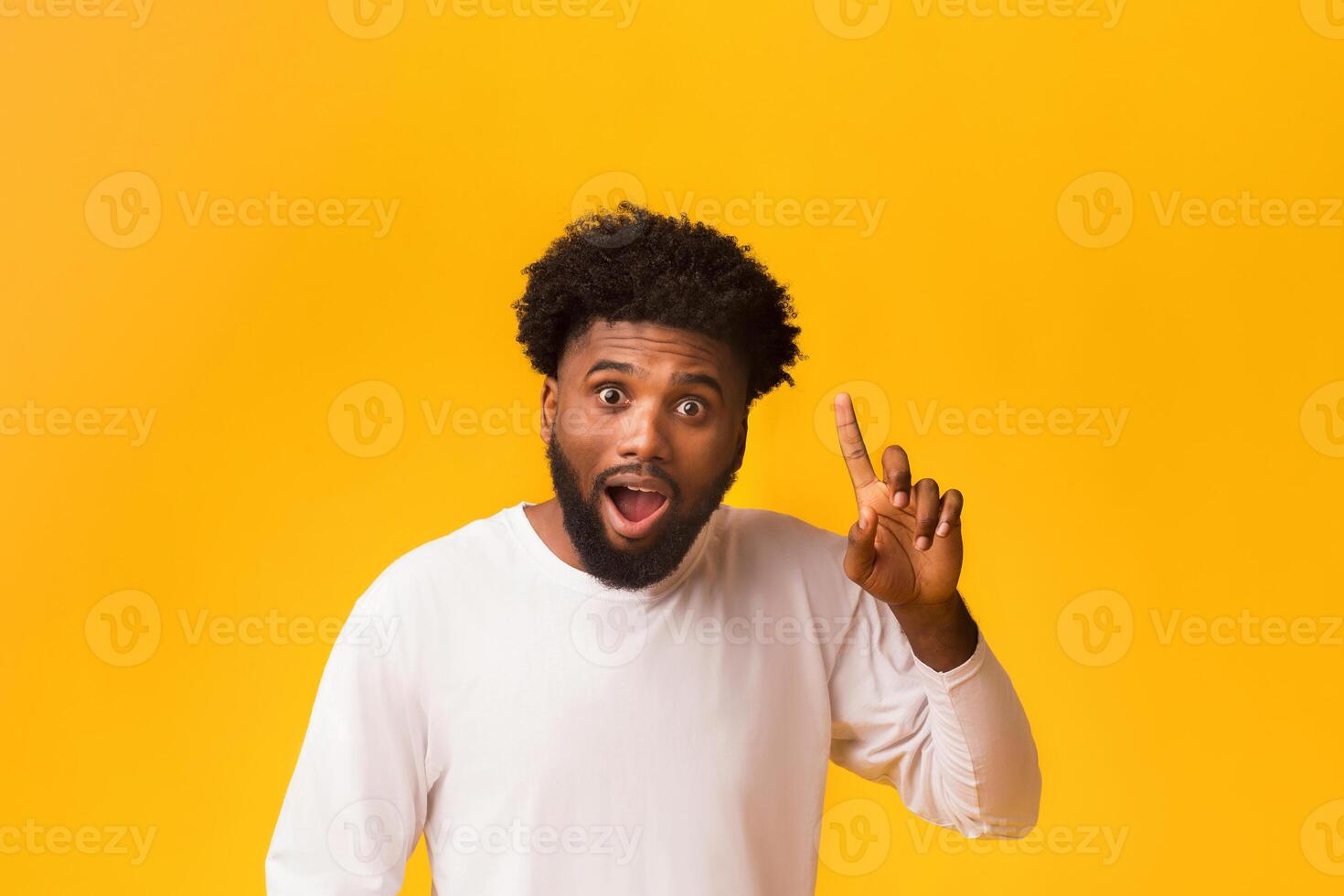 Young african american man having idea, pointing finger up, suddenly got problem solution photo