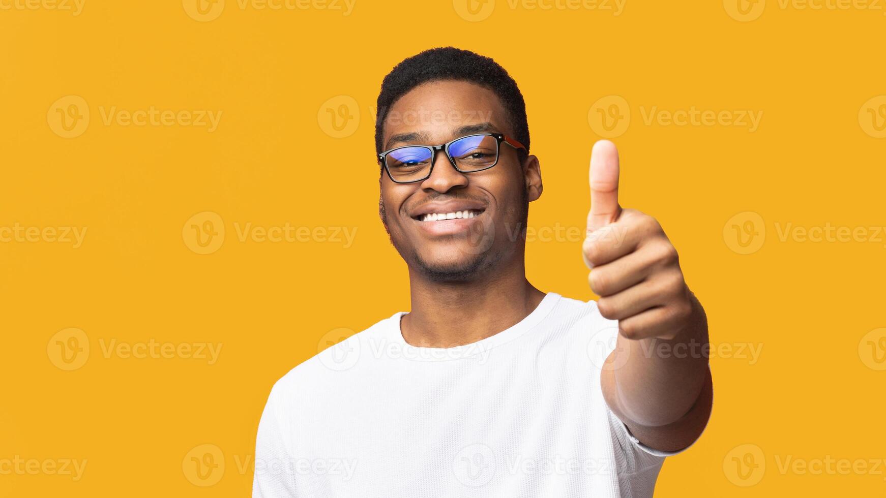 Human Reaction Concept. Black man showing thumb up isolated over orange background. Copy space photo