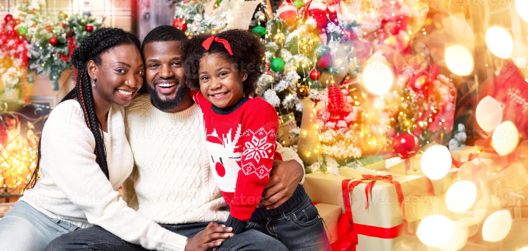 Merry Christmas and happy holidays. Portrait of joyful african american family of three posing in Xmas interior photo