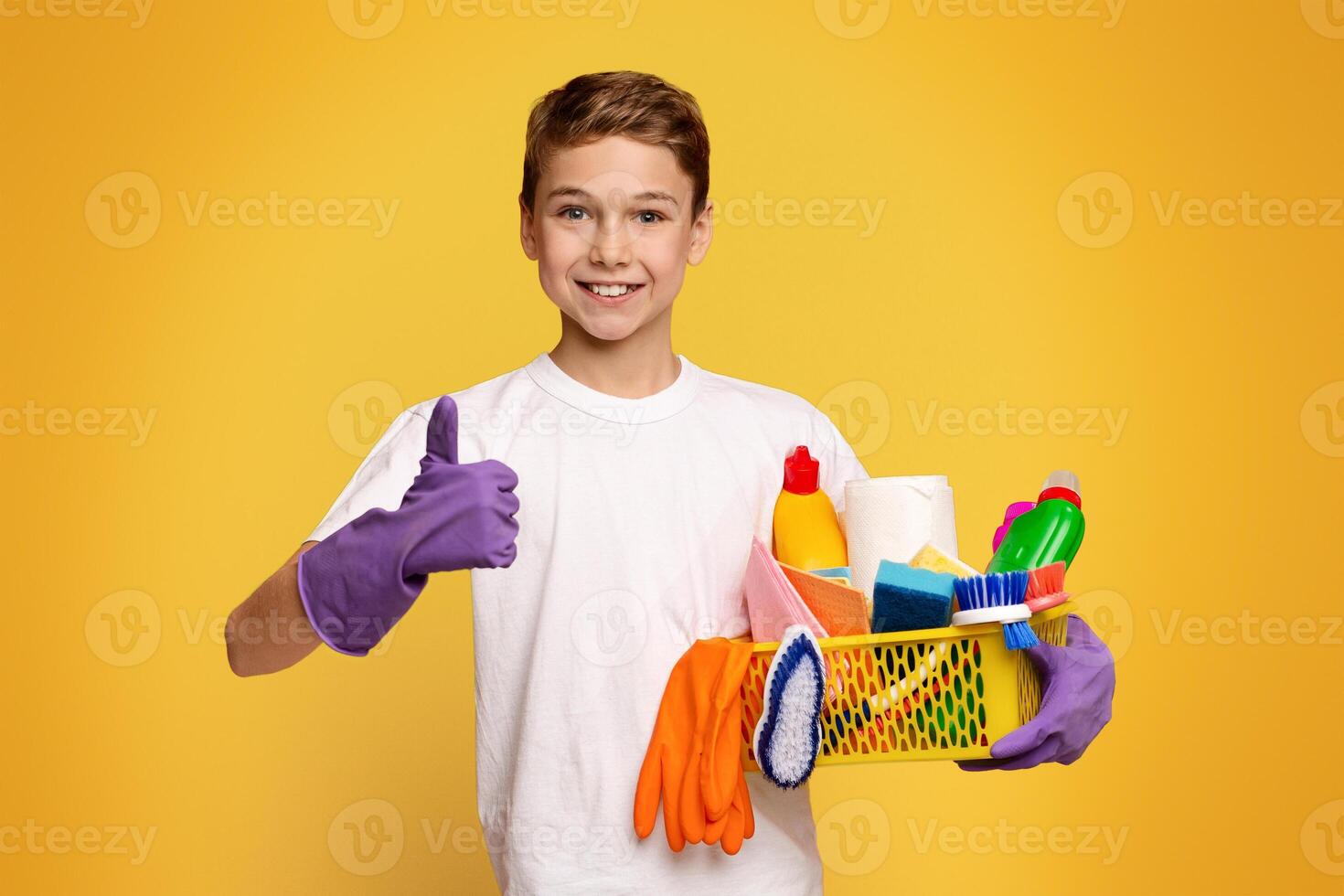 A young boy is shown standing with a basket filled with cleaning supplies. photo