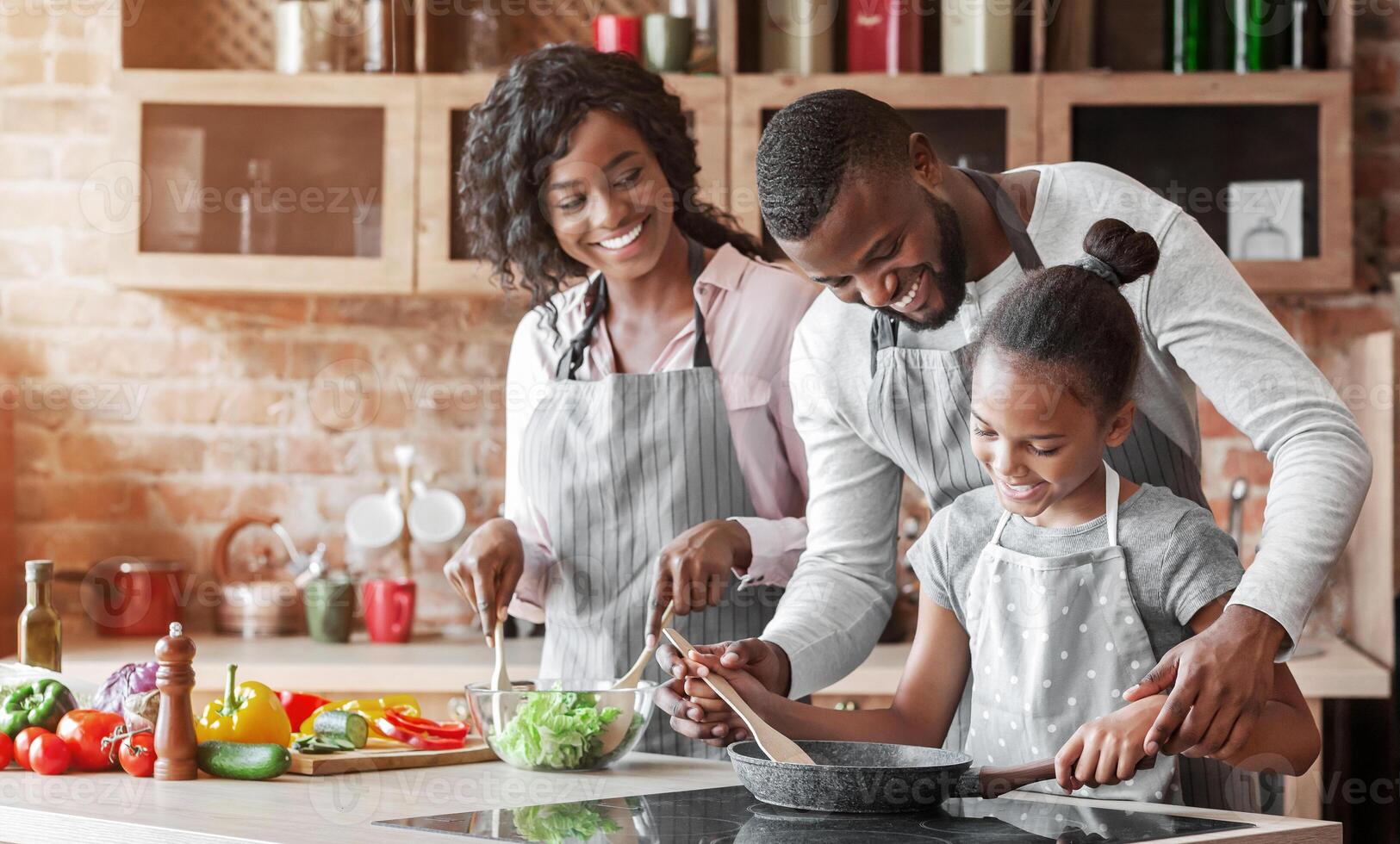 Kind african parents teaching their adorable daughter how to cook healthy food, free space photo