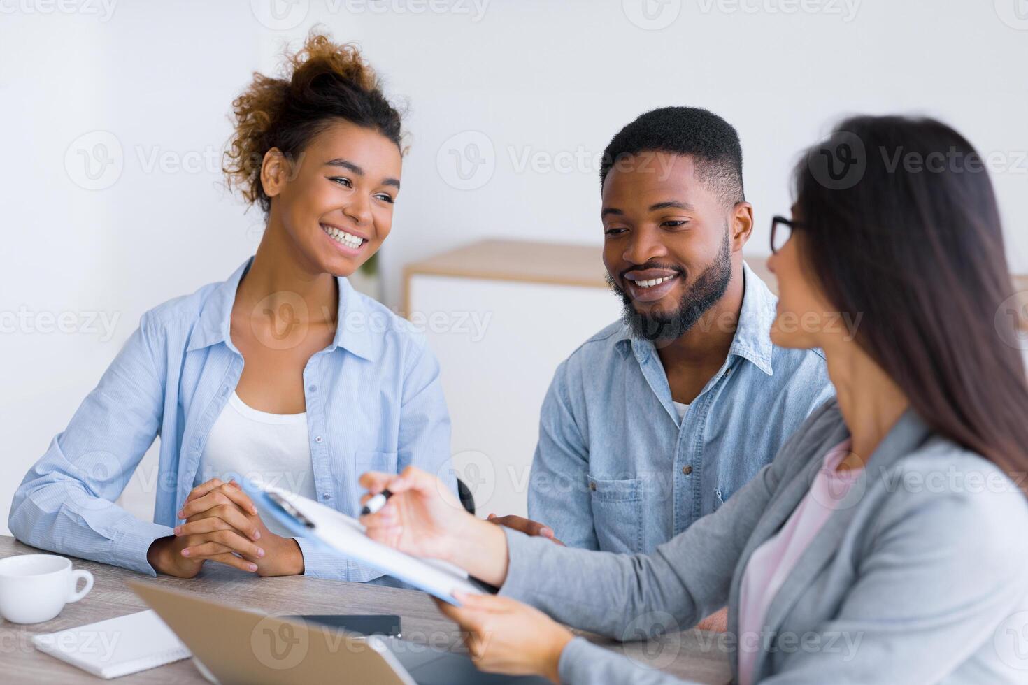 Financial Consultation. Cheerful Black Couple Smiling And Listening To Their Investment Advisor In Office. Selective focus photo