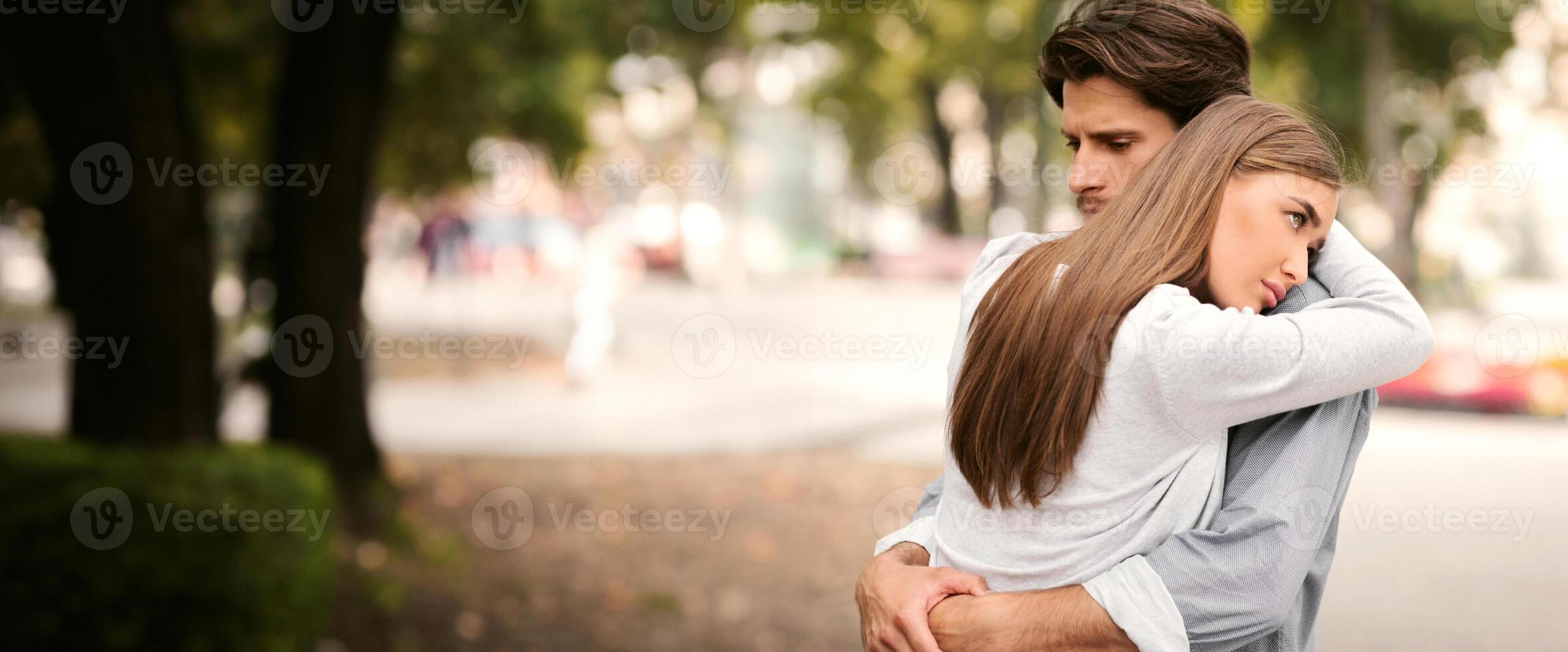 Unhappy Relationship. Sad Guy And Girl Hugging Feeling Unloved And Stuck In Relations Standing In Park Outdoors. Copy Space photo