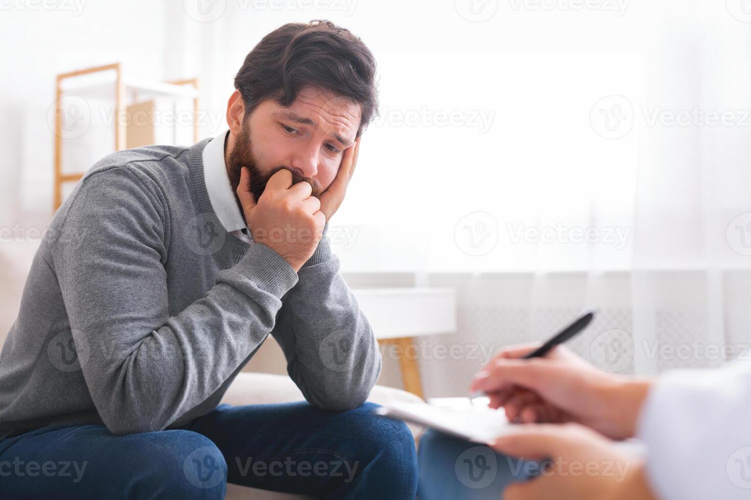 Man with depression during psychotherapy session, talking about his loneliness, free space photo