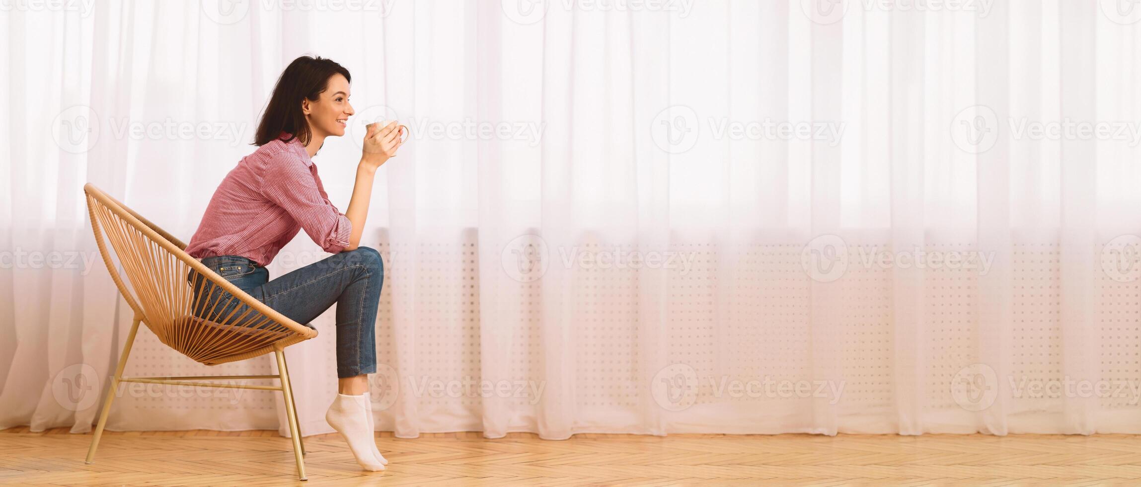 Peaceful Morning. Calm Girl Sitting In Modern Chair, Enjoying Hot Coffee In Front Of Window, Side View photo