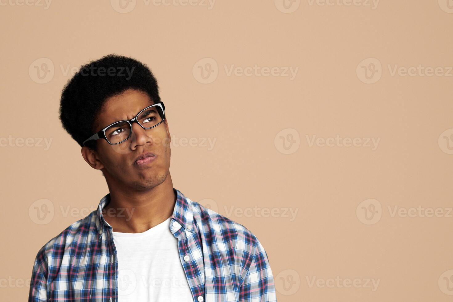 Thoughtful Afro Guy Thinking and Looking Aside over White Background photo