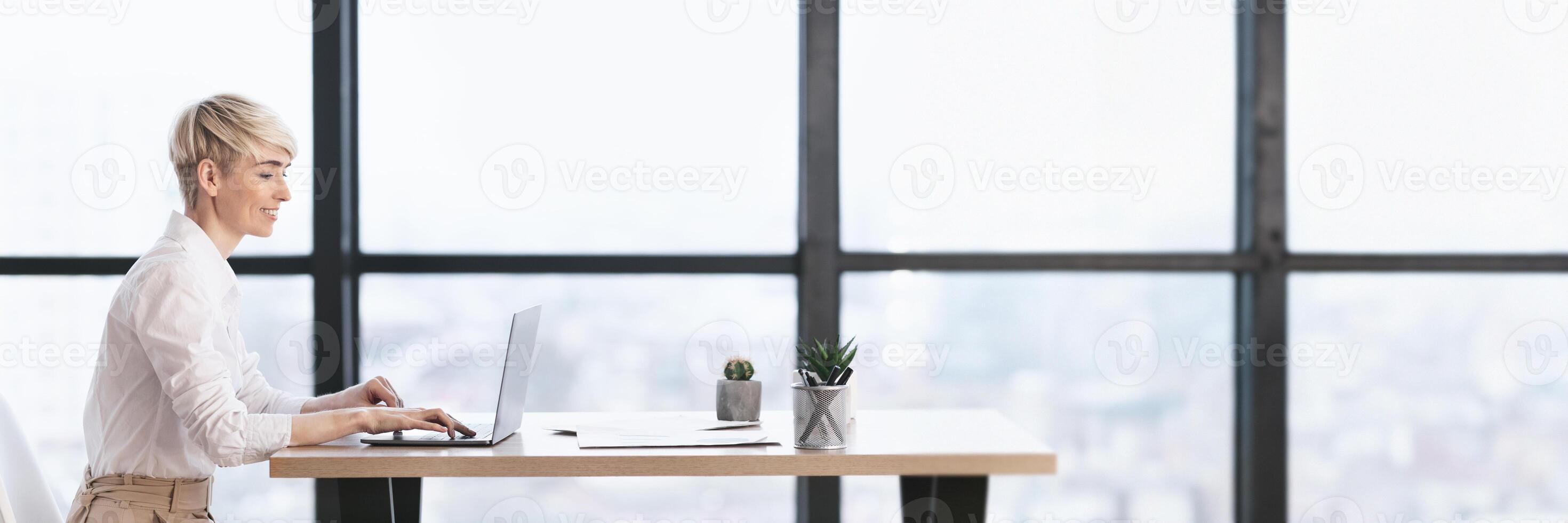 Successful Business Career. Businesswoman Working At Laptop Sitting In Modern Office. Side View, Free Space, Web-banner photo