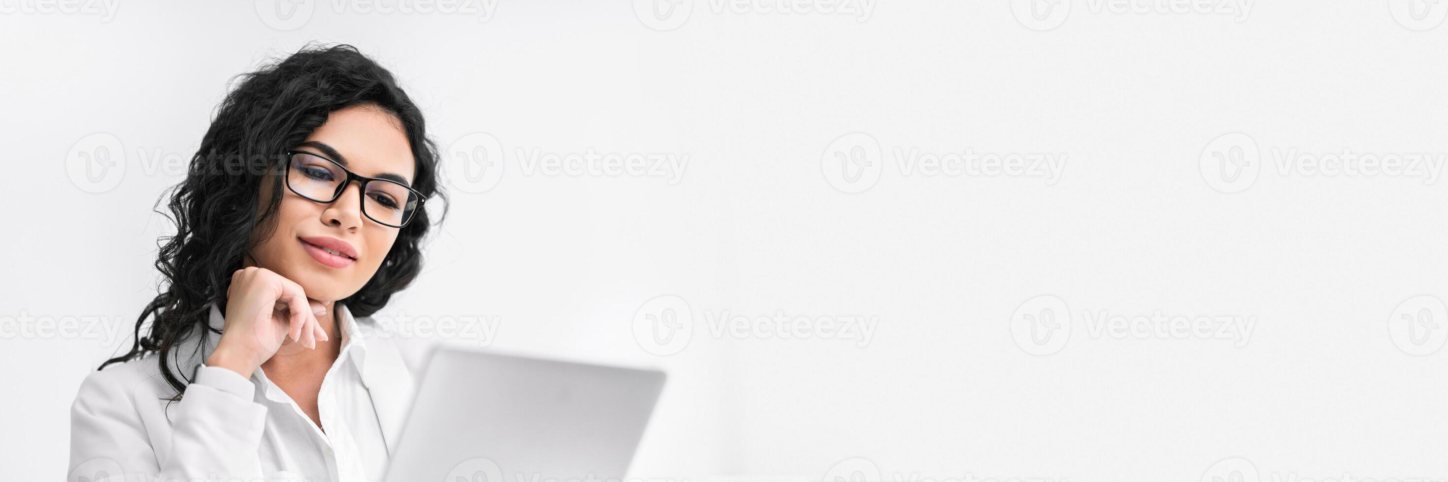 Office Person. Beautiful hispanic businesswoman using digital tablet working at modern office, vertical image, panorama with copy space photo