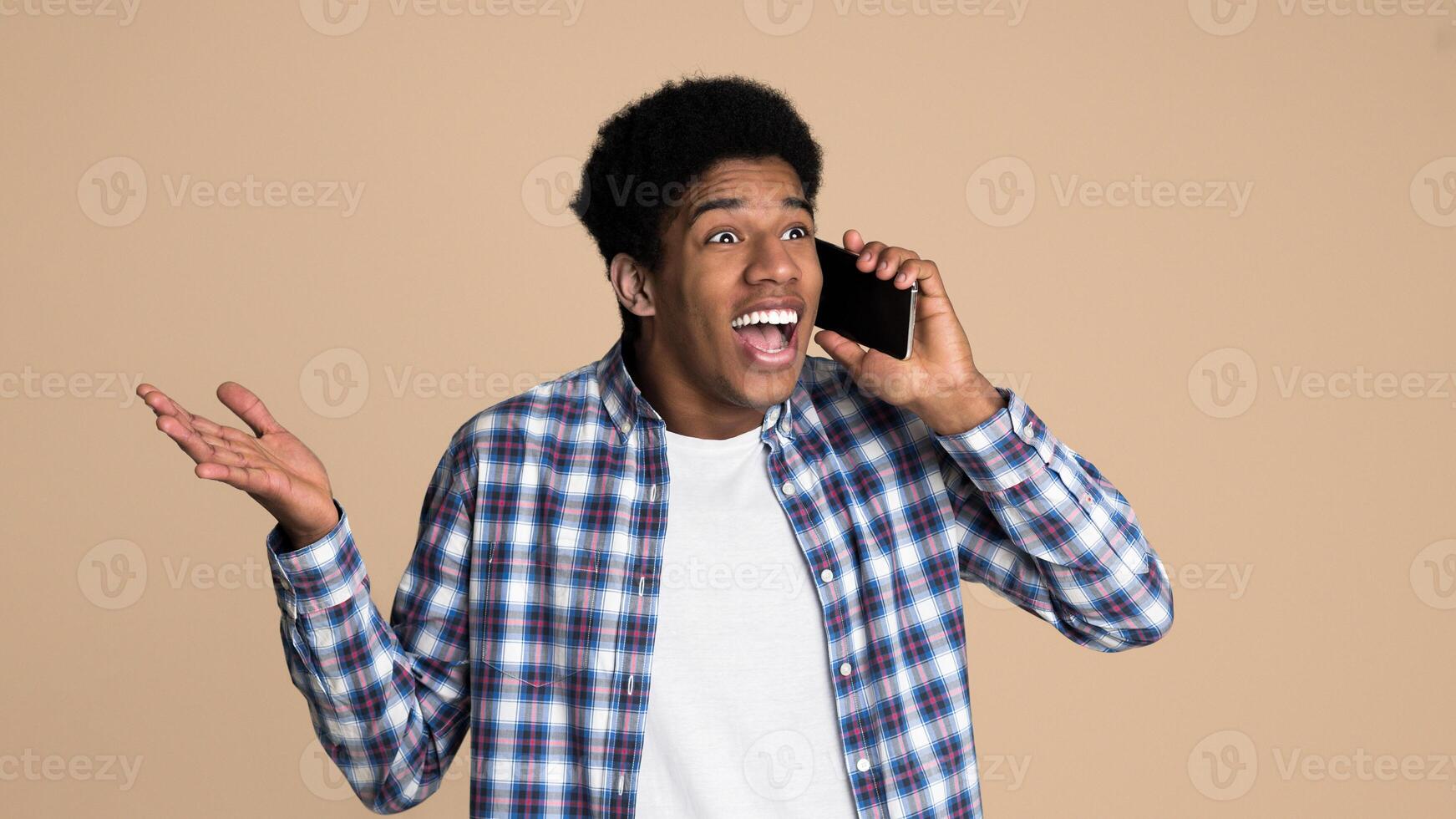Unexpected call. Surprised guy talking on phone over white background photo