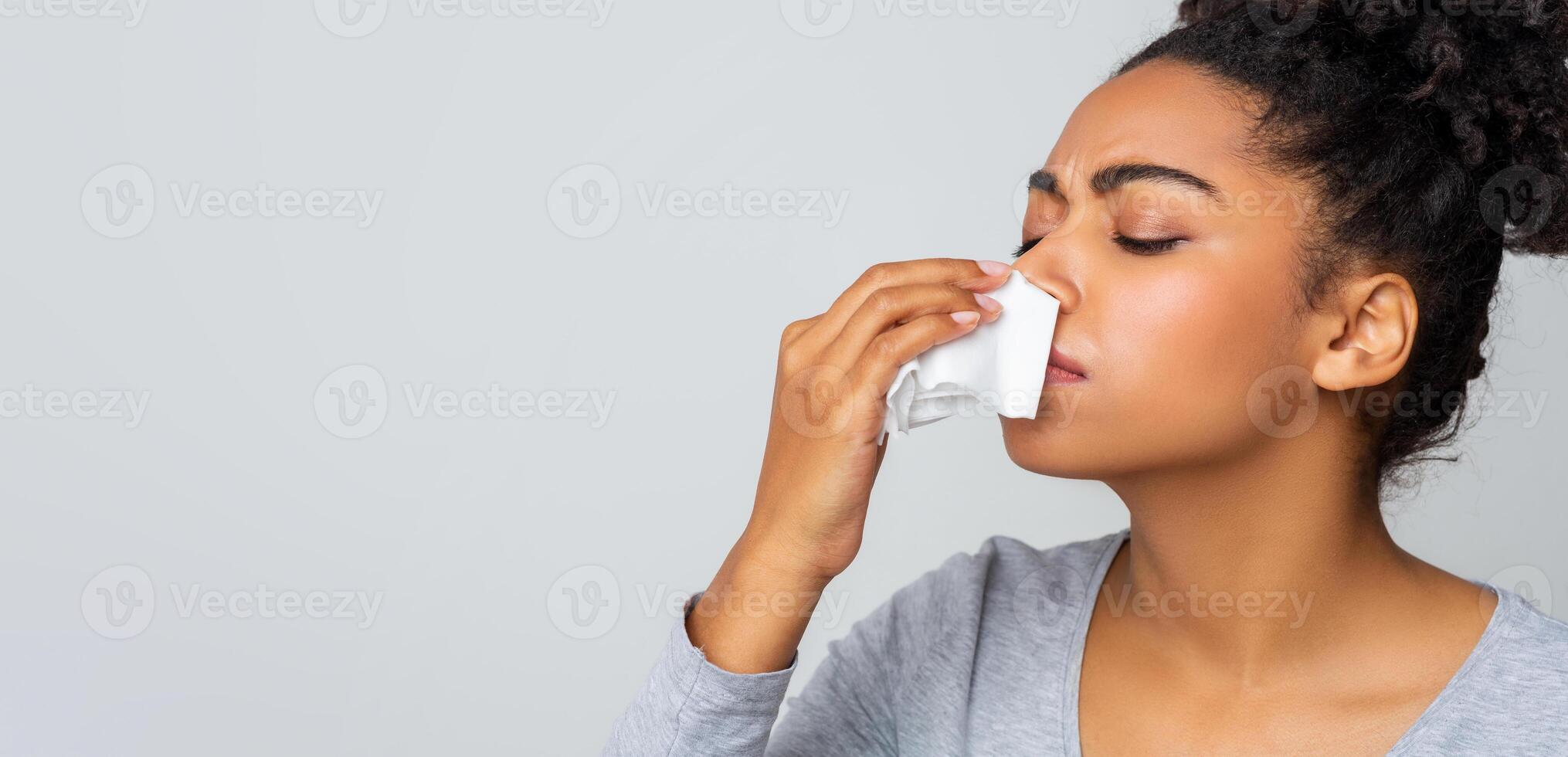 Afro woman touching her nose with napkin, bleeding or having runny nose, free space photo